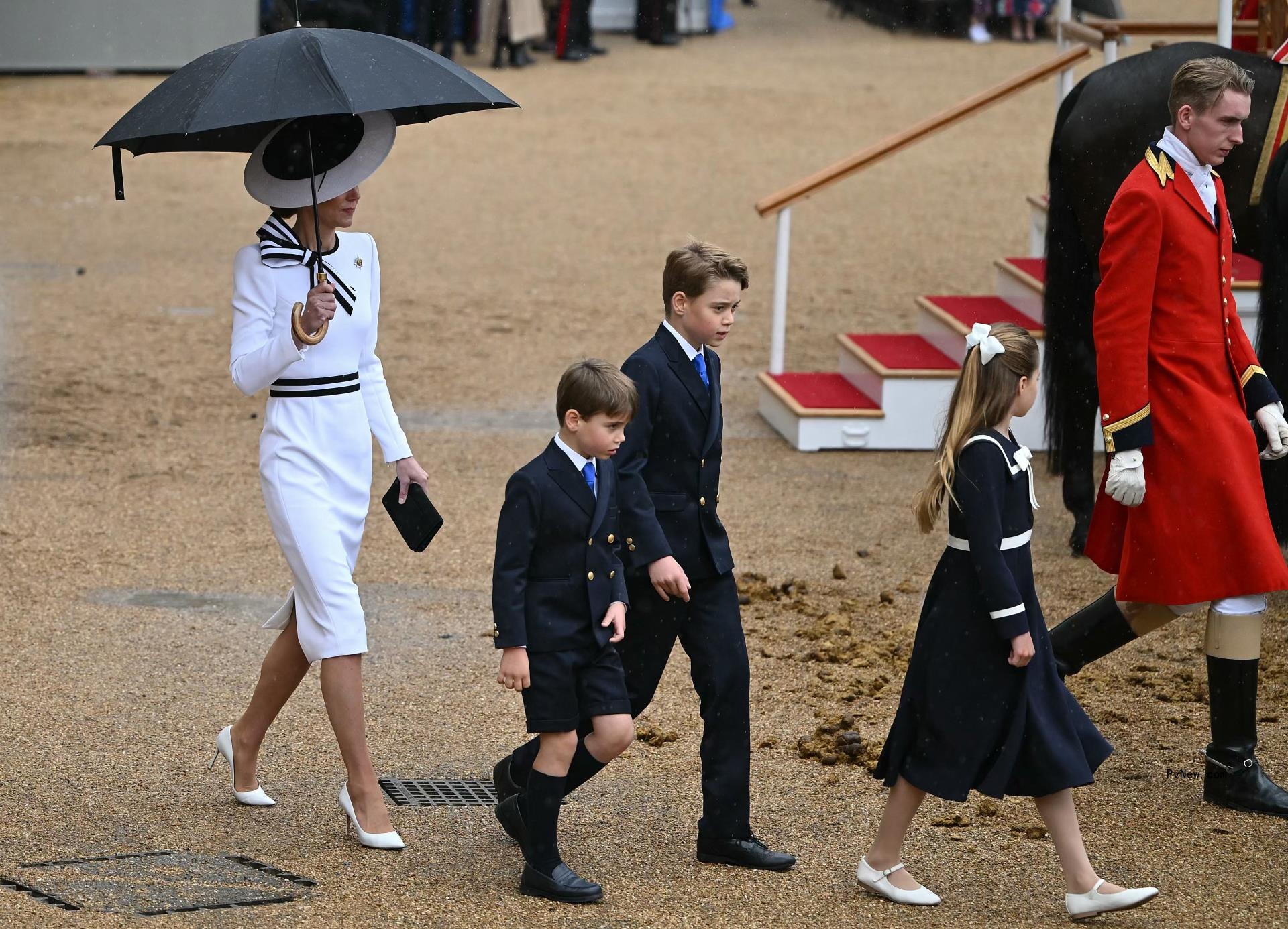 Britain's Catherine, Princess of Wales, shelters from the rain with an umbrella as she walks with her children Britain's Prince George of Wales (C), Britain's Princess Charlotte of Wales (R) and Britain's Prince Louis of Wales back to the Glass State Coach at Horse Guards Parade during the King's Birthday Parade