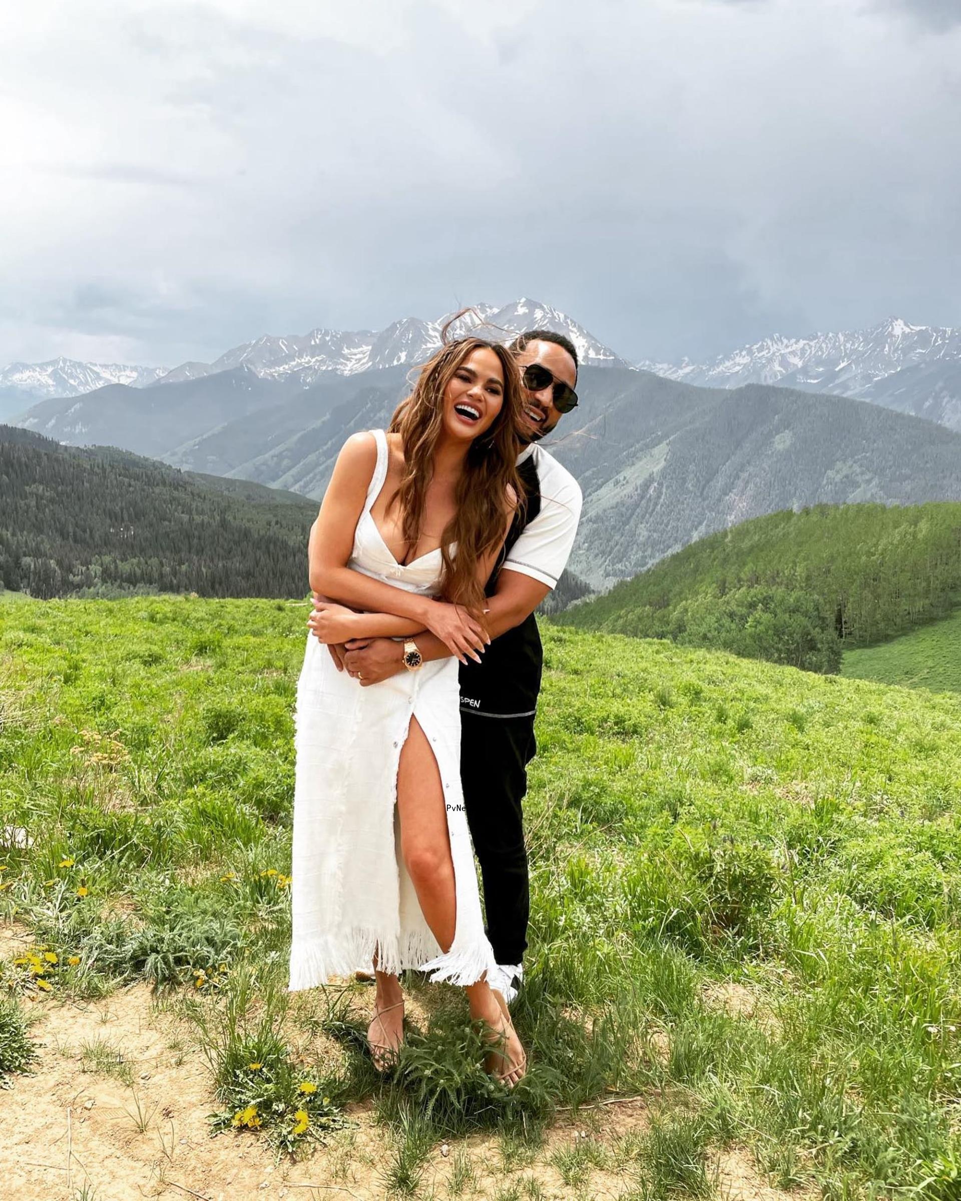 John legend and Chrissy Teigen posing for a photo together. 