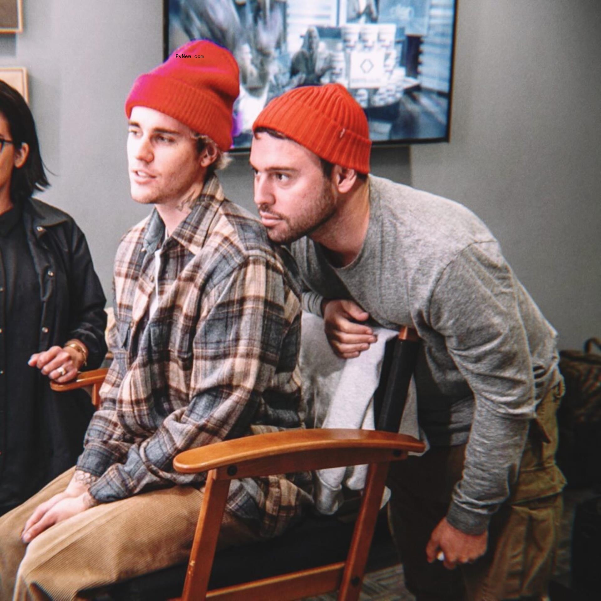 Scooter Braun and Justin Bieber in orange hats. 