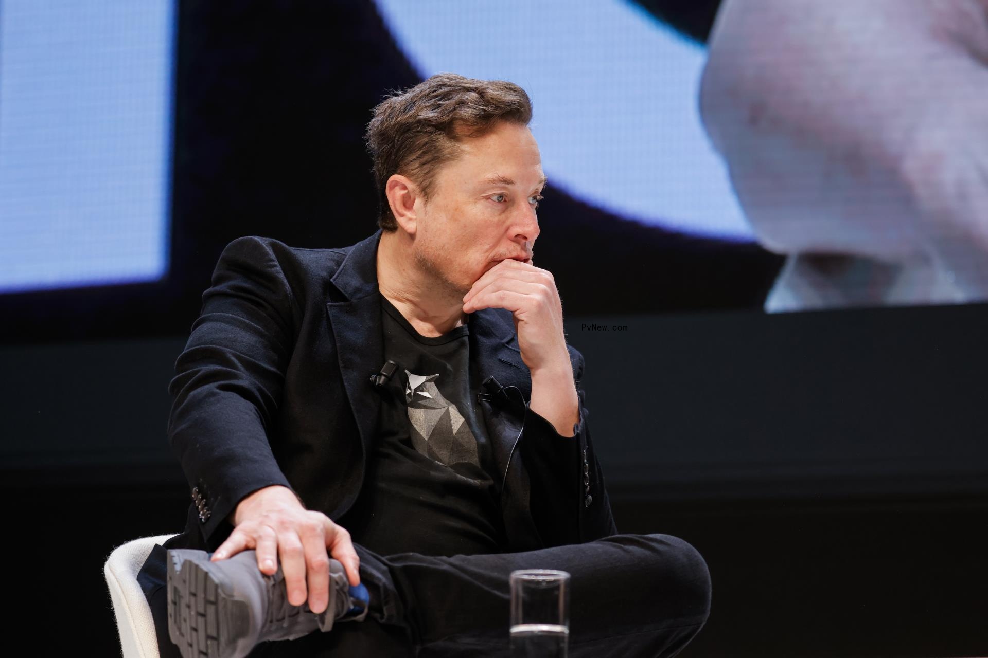 elon musk with his hand on his chin