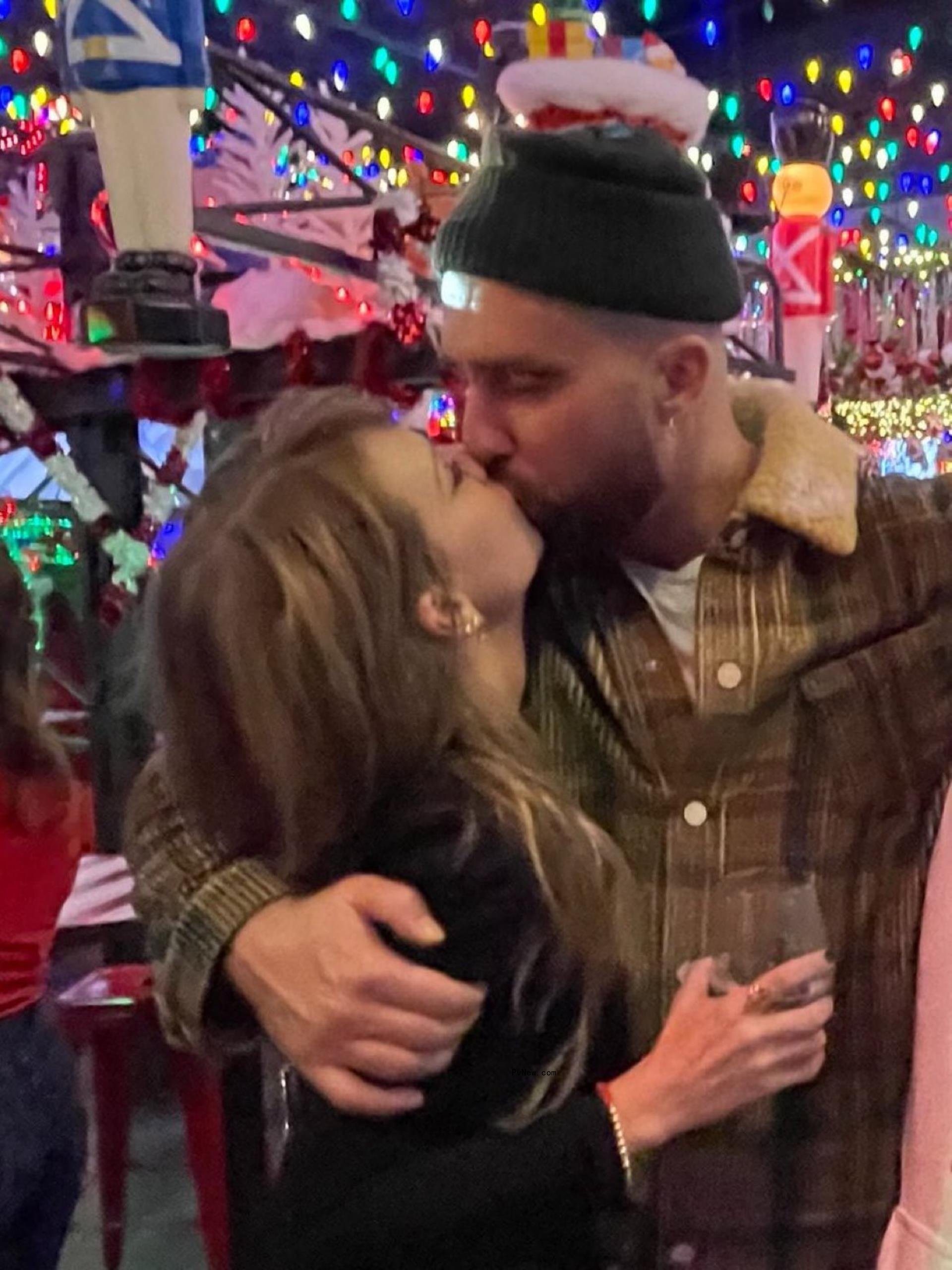 Travis Kelce and Taylor Swift kissing.