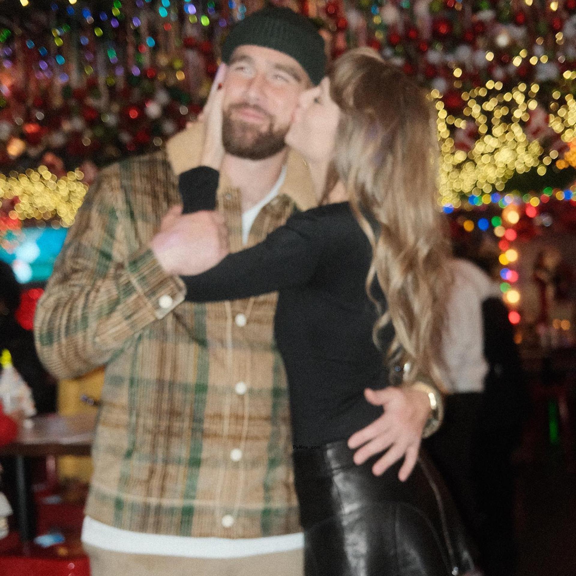 Travis Kelce and Taylor Swift kissing.