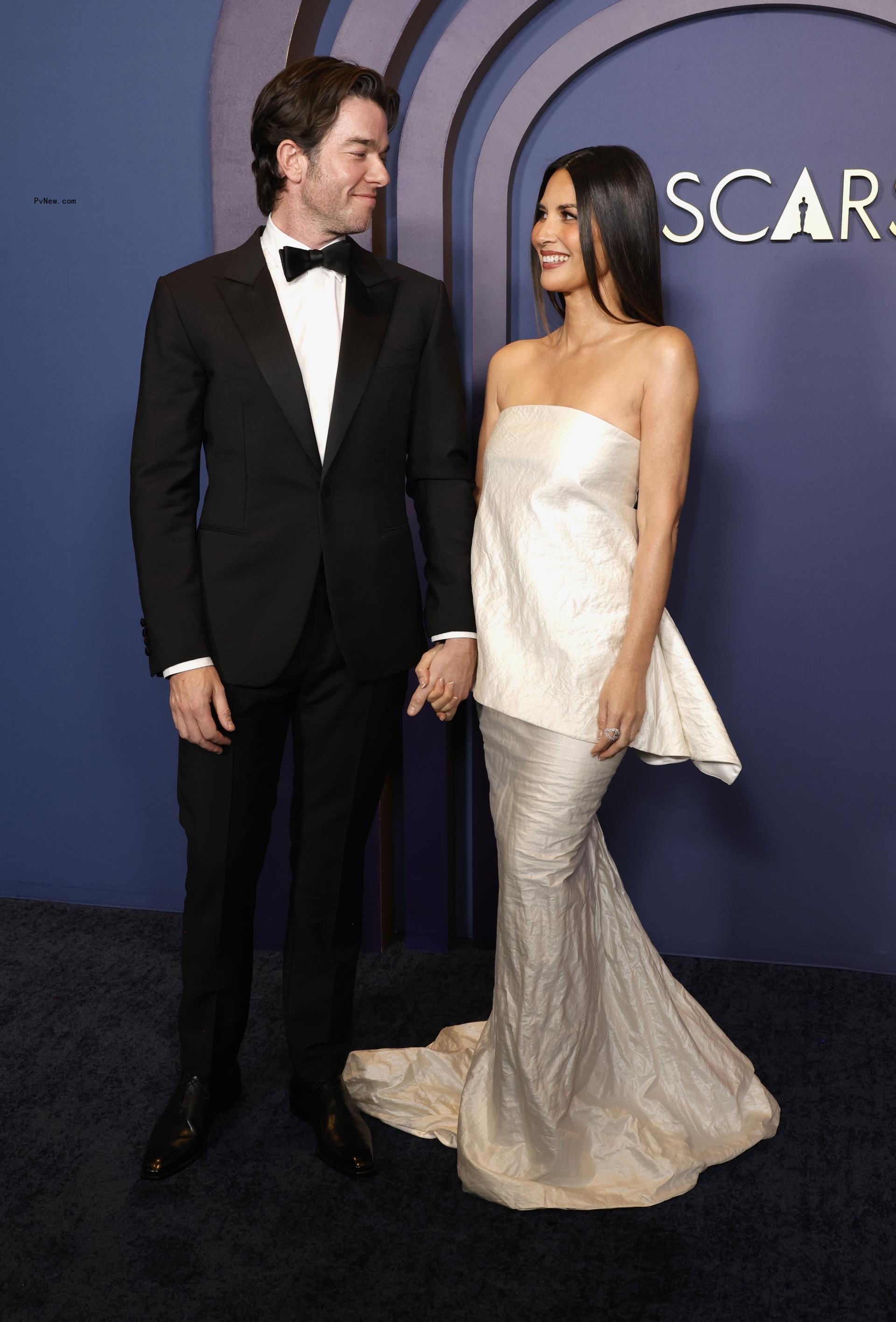 John Mulaney and Olivia Munn on a red carpet. 