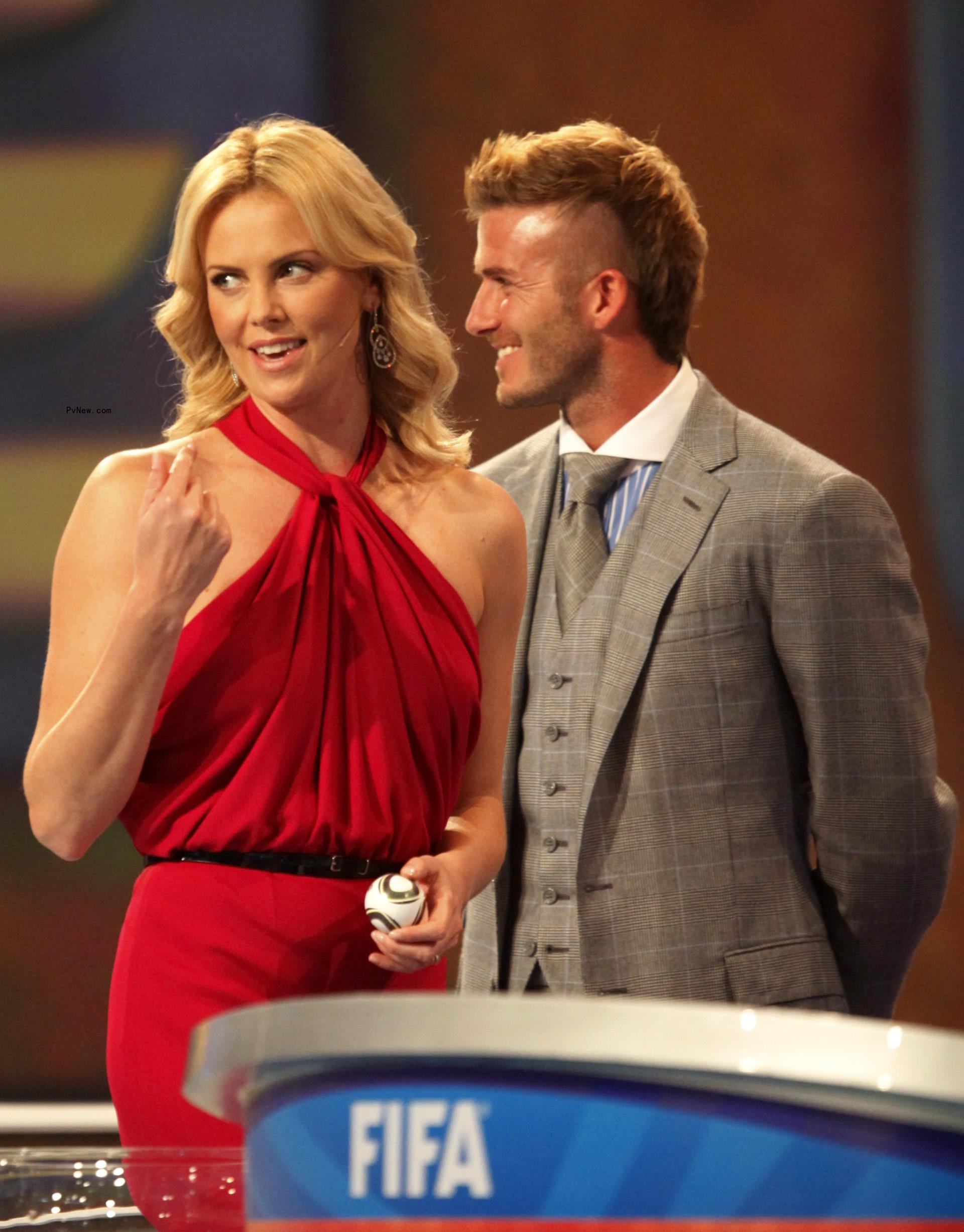 David Beckham grins at Charlize Theron.