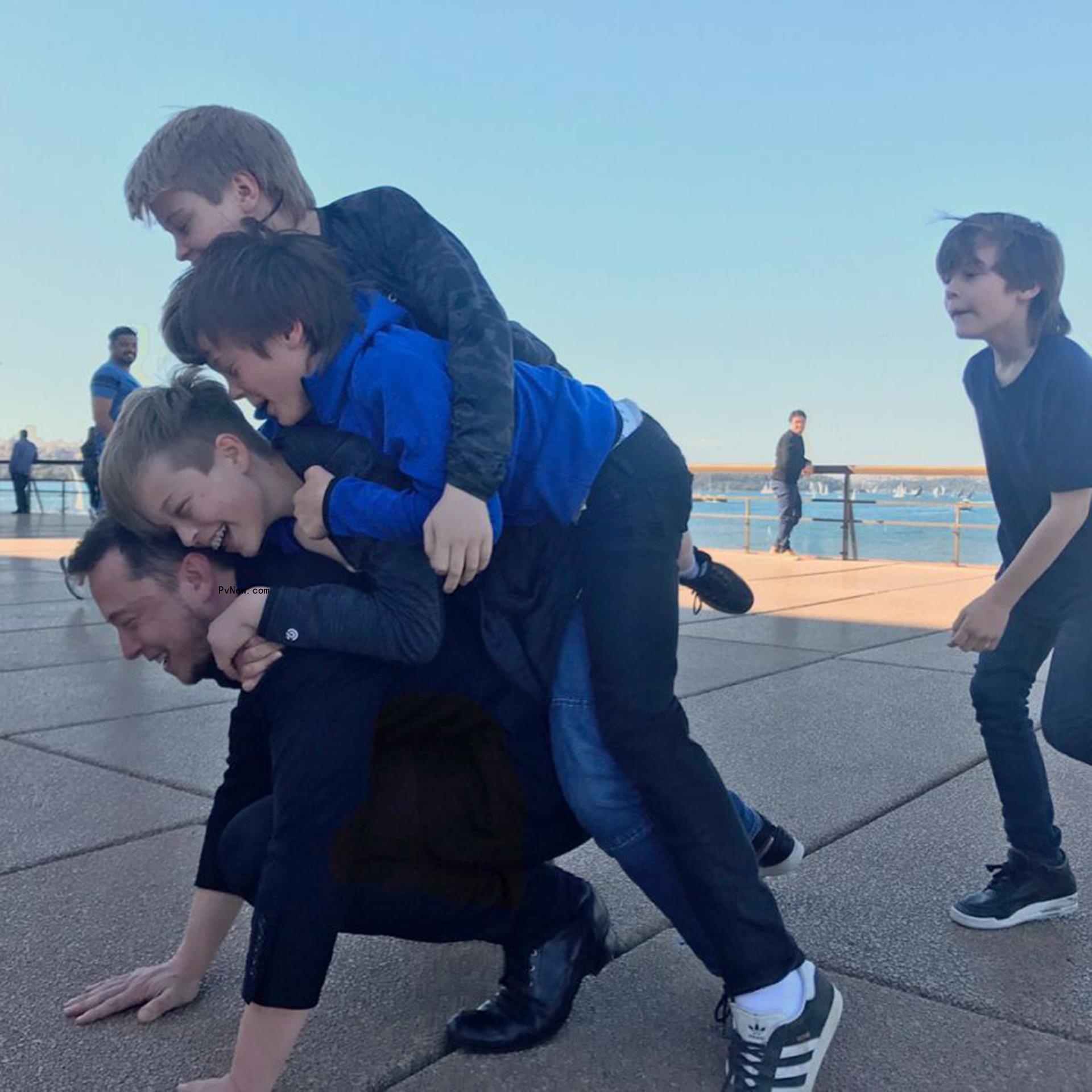 Elon Musk with his sons on his back.