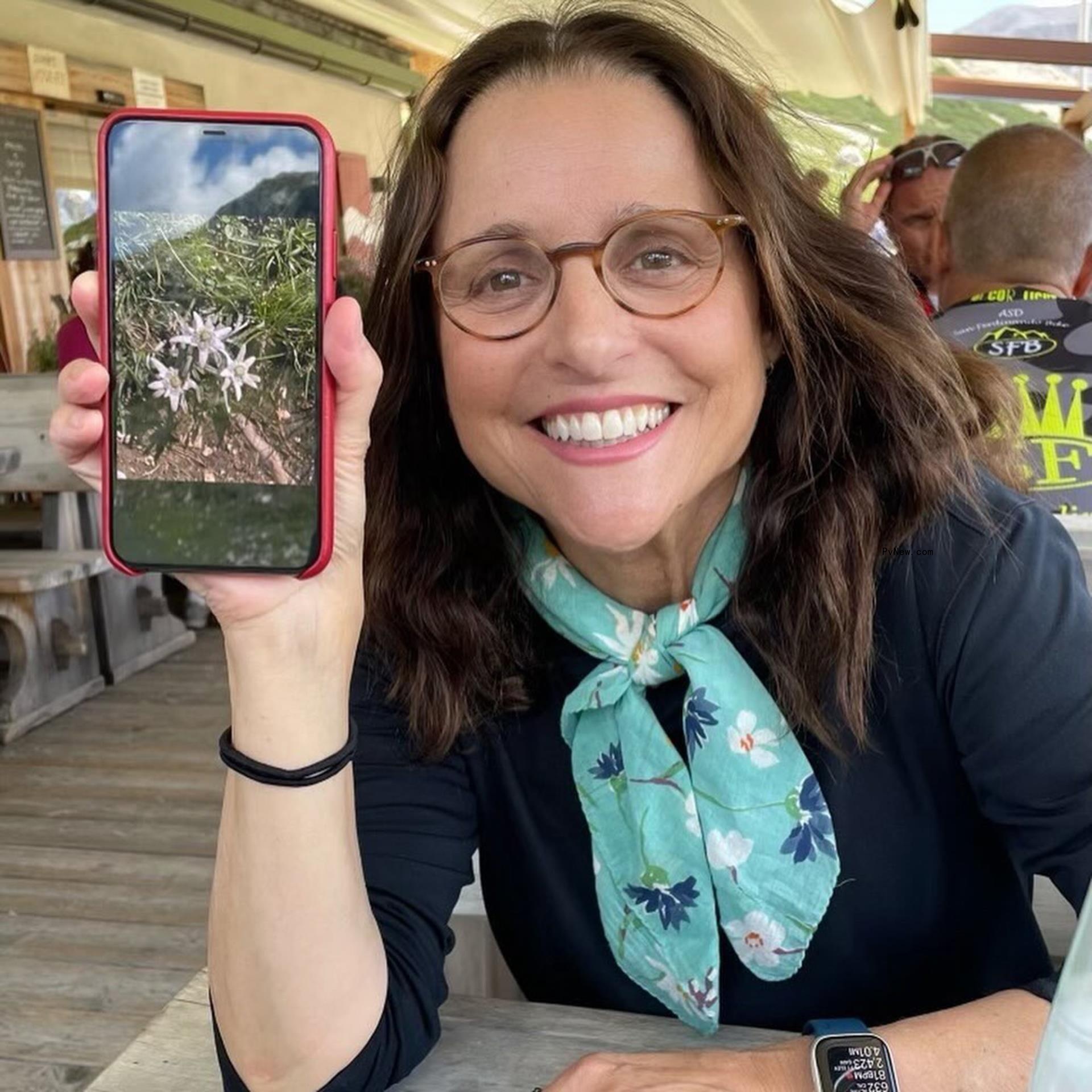 Julia Louis-Dreyfus holding up a photo on her phone.