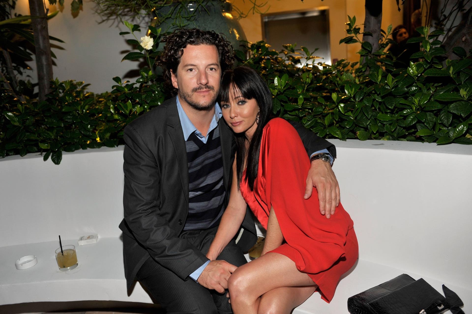 shannen doherty wearing a head cap posing next to then-husband kurt iswarienko