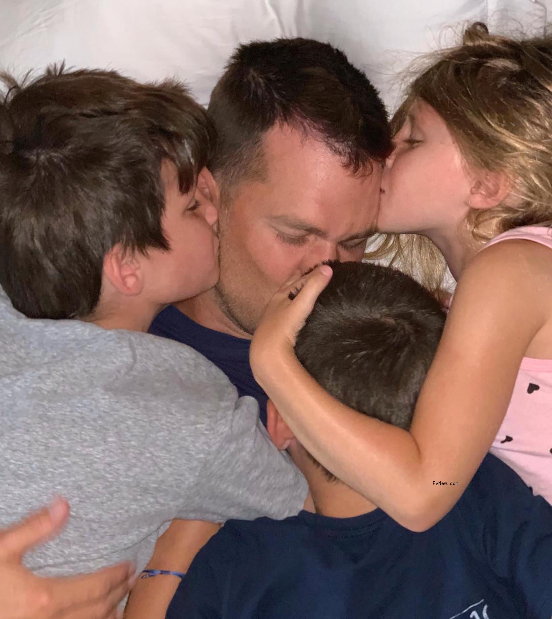 Tom Brady cuddling with Jack, Benjamin and Vivian Brady.