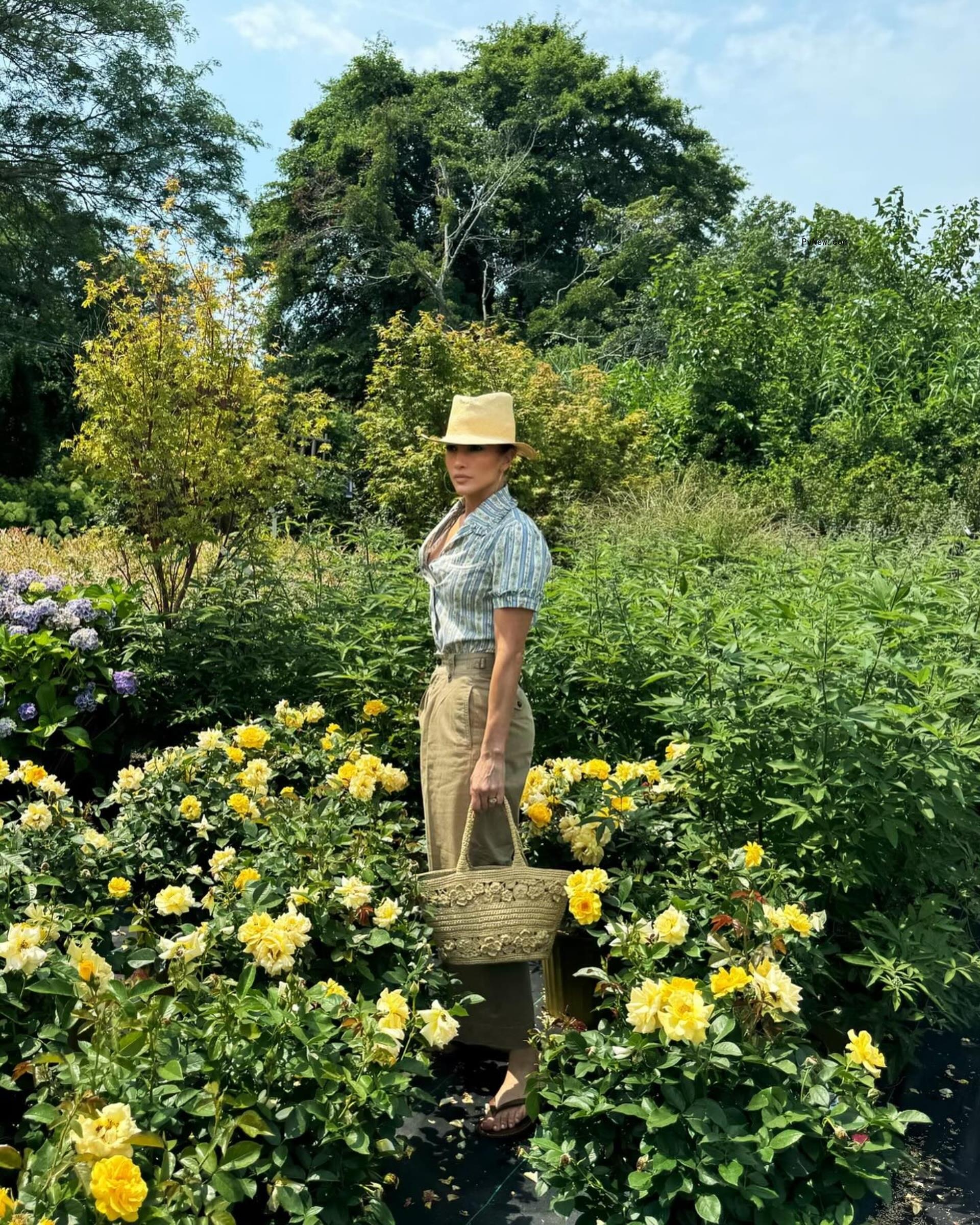 Jennifer Lopez posing for a photo in a field