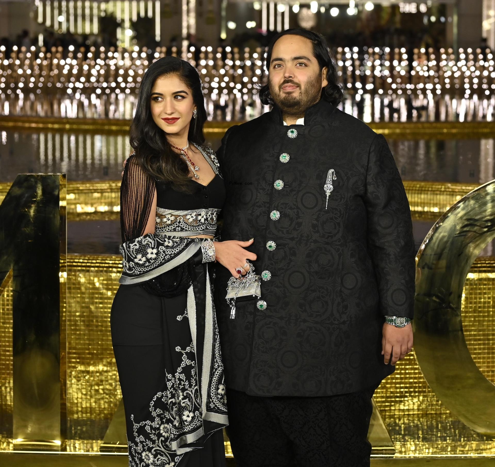 Anant Ambani and Radhika Merchant posing on a red carpet.