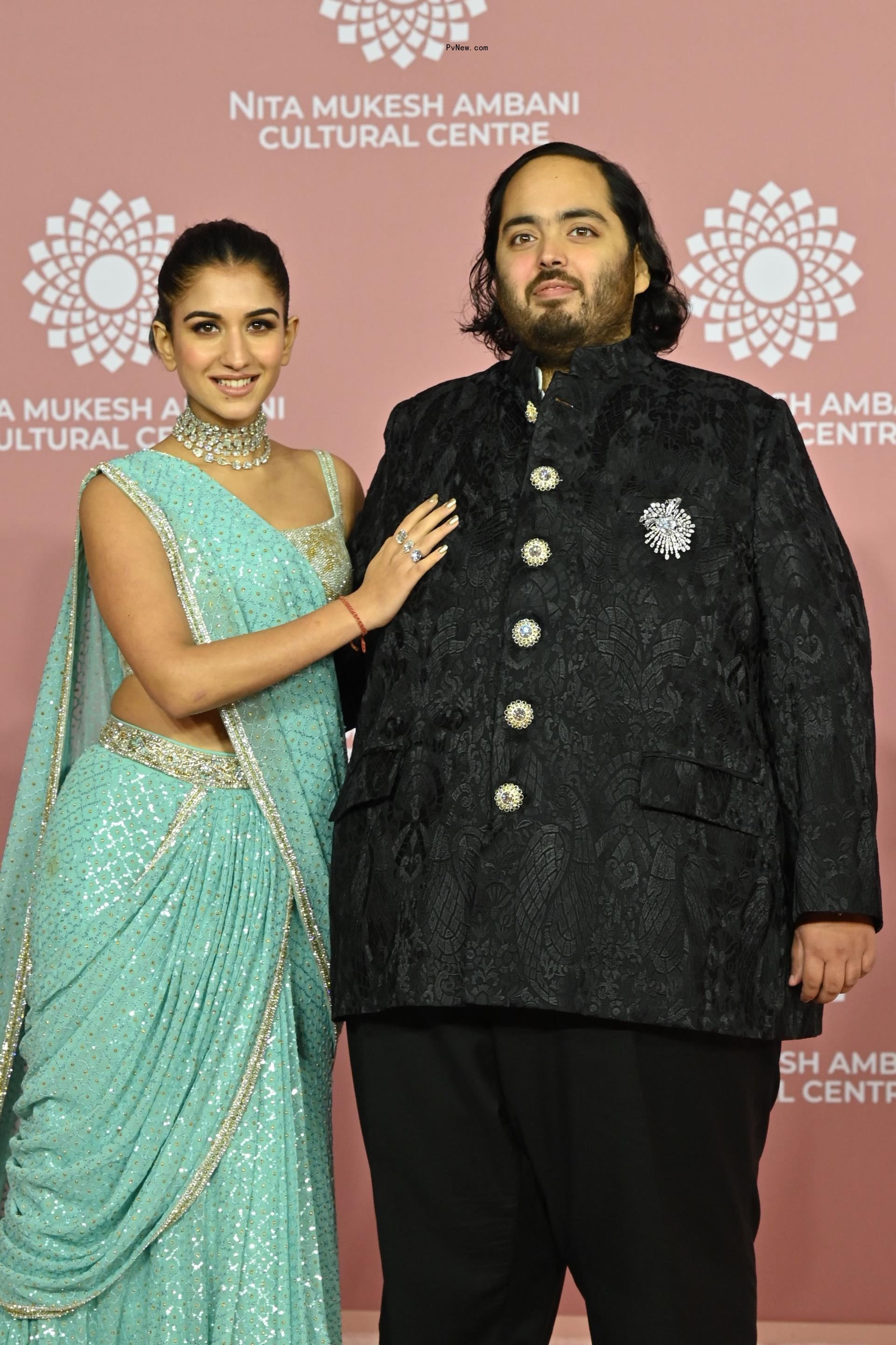 Anant Ambani and Radhika Merchant posing on a red carpet.