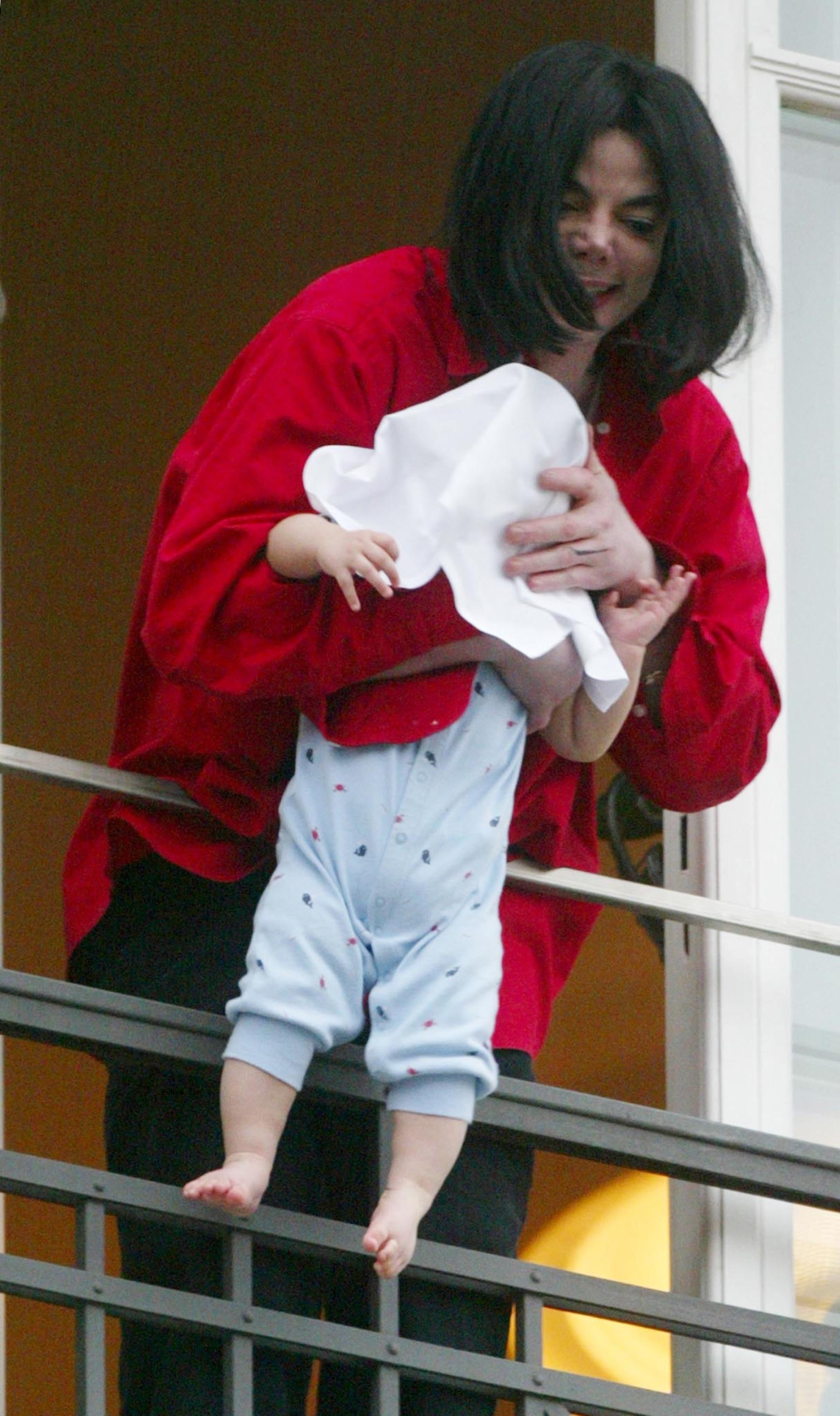 Michael Jackson hanging his son Blanket over a balcony.