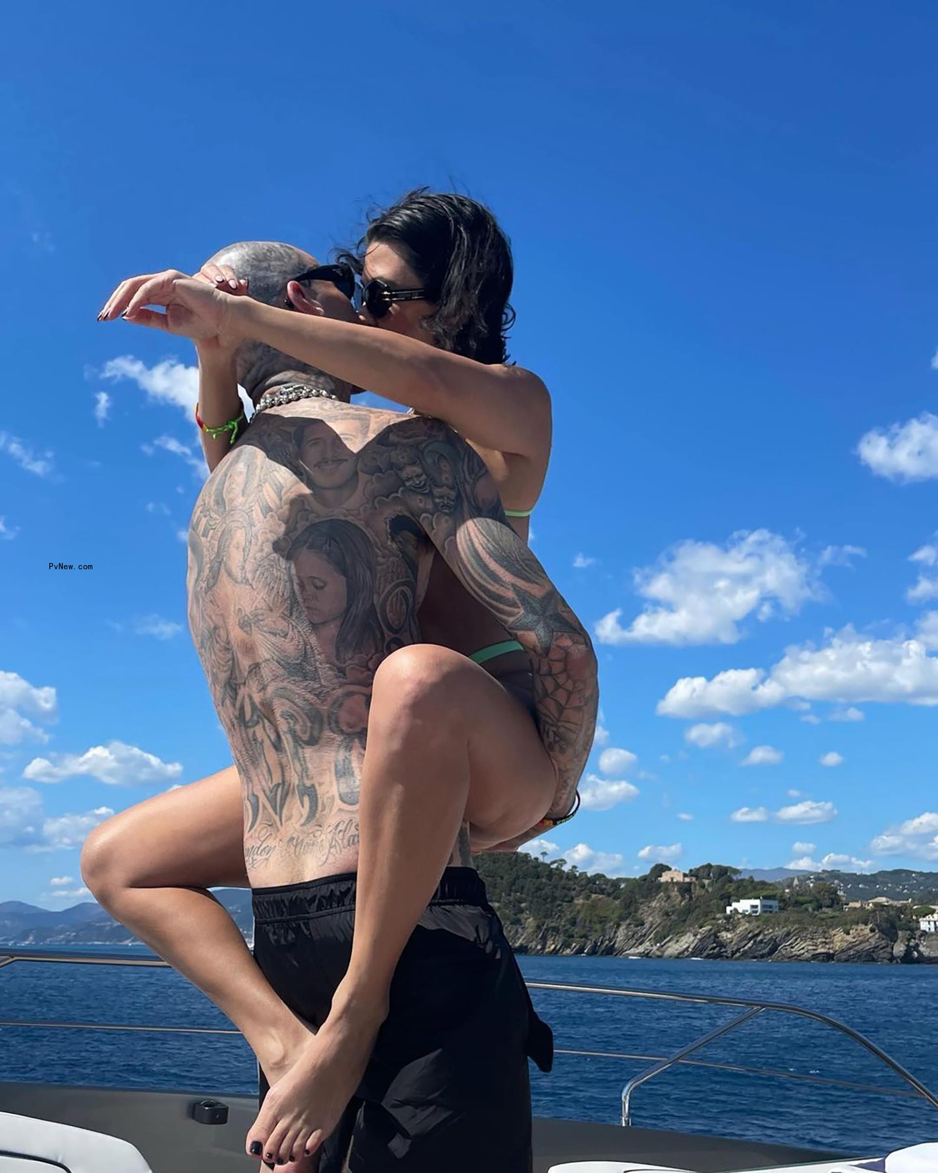 Kourtney Kardashian and Travis Barker kissing. 