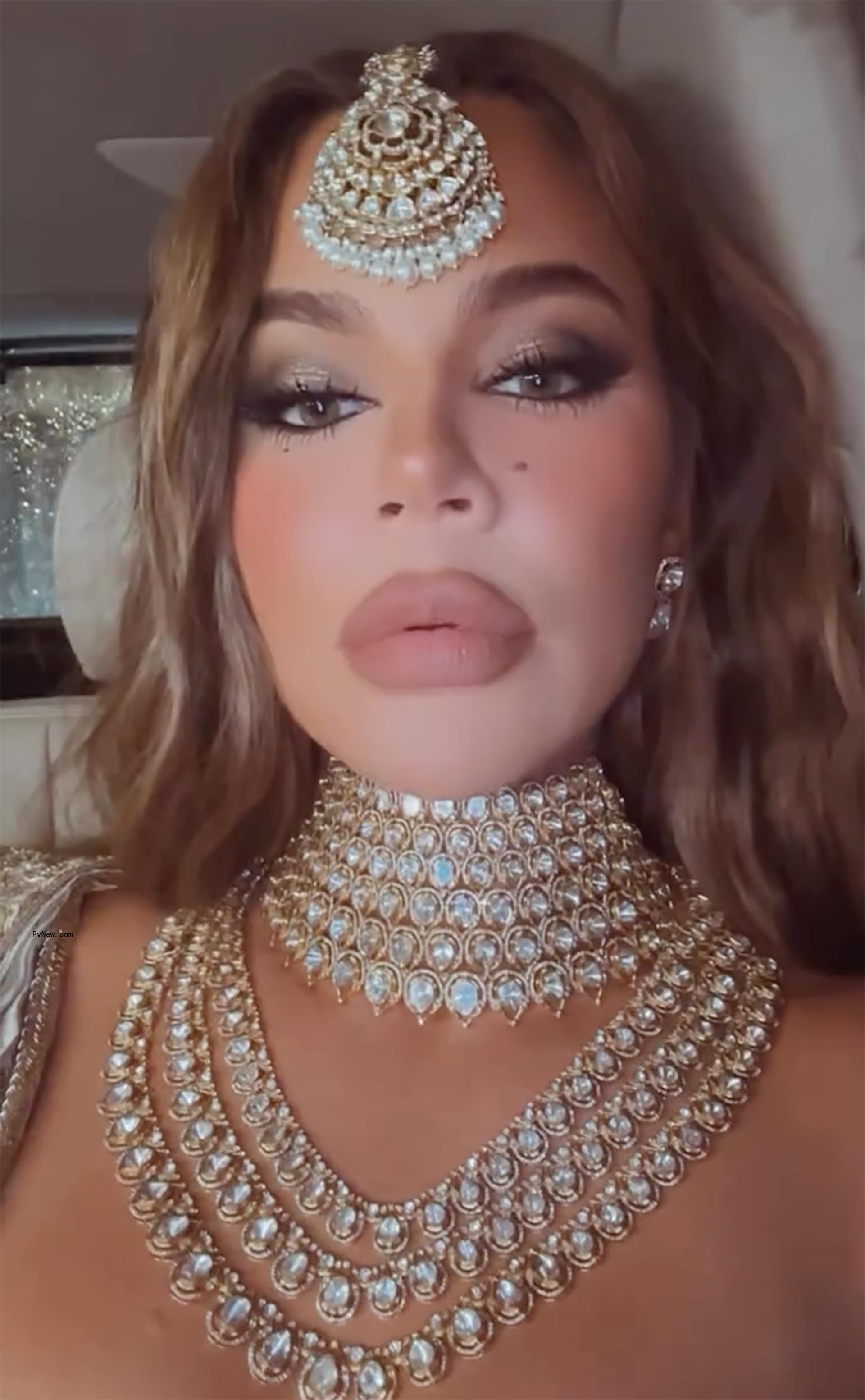 Khloé Kardashian trying to snap on Kim Kardashian bodysuit