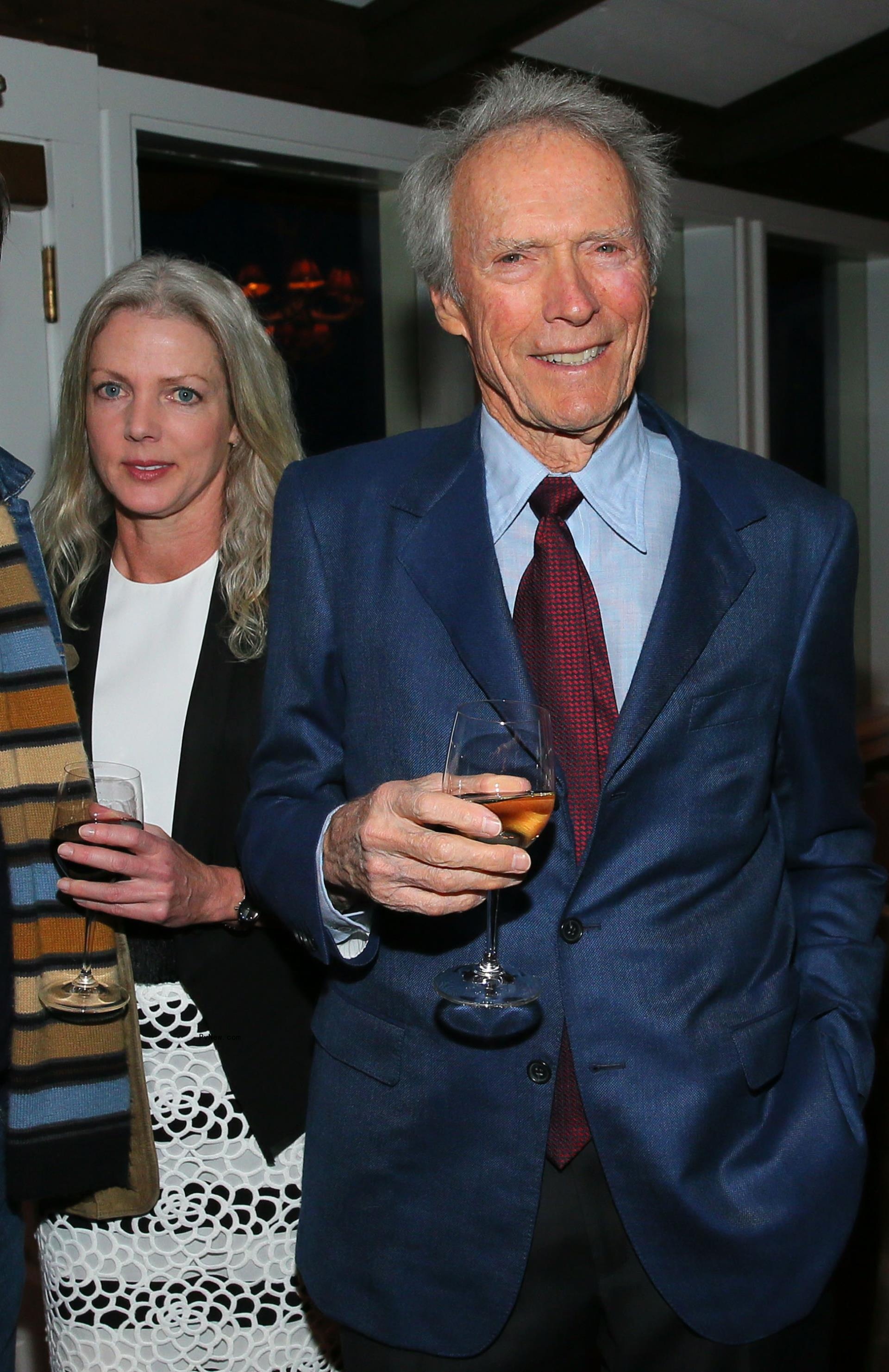 christina sandera and clint eastwood, who is holding a cocktail