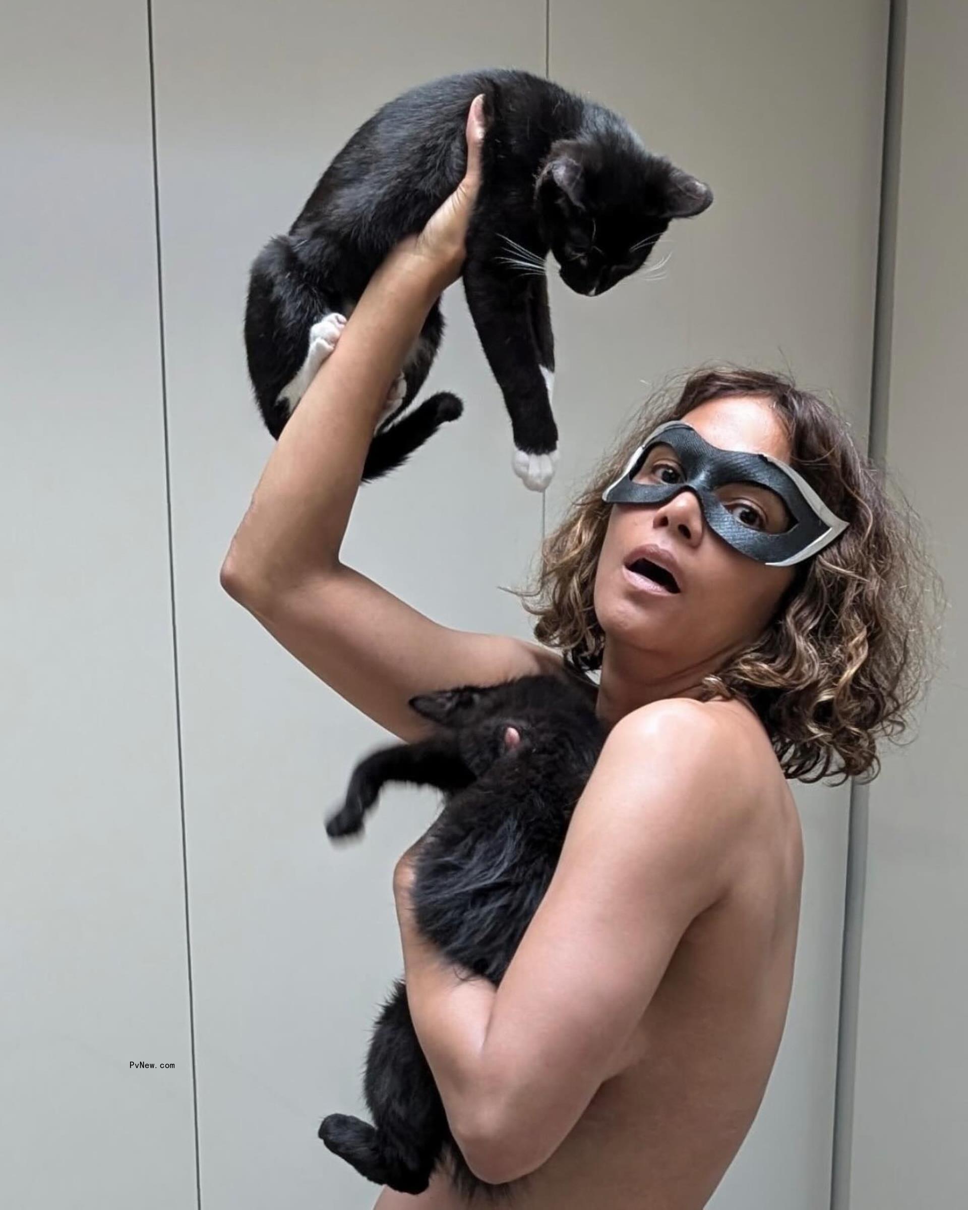 Halle Berry posing with two cats.