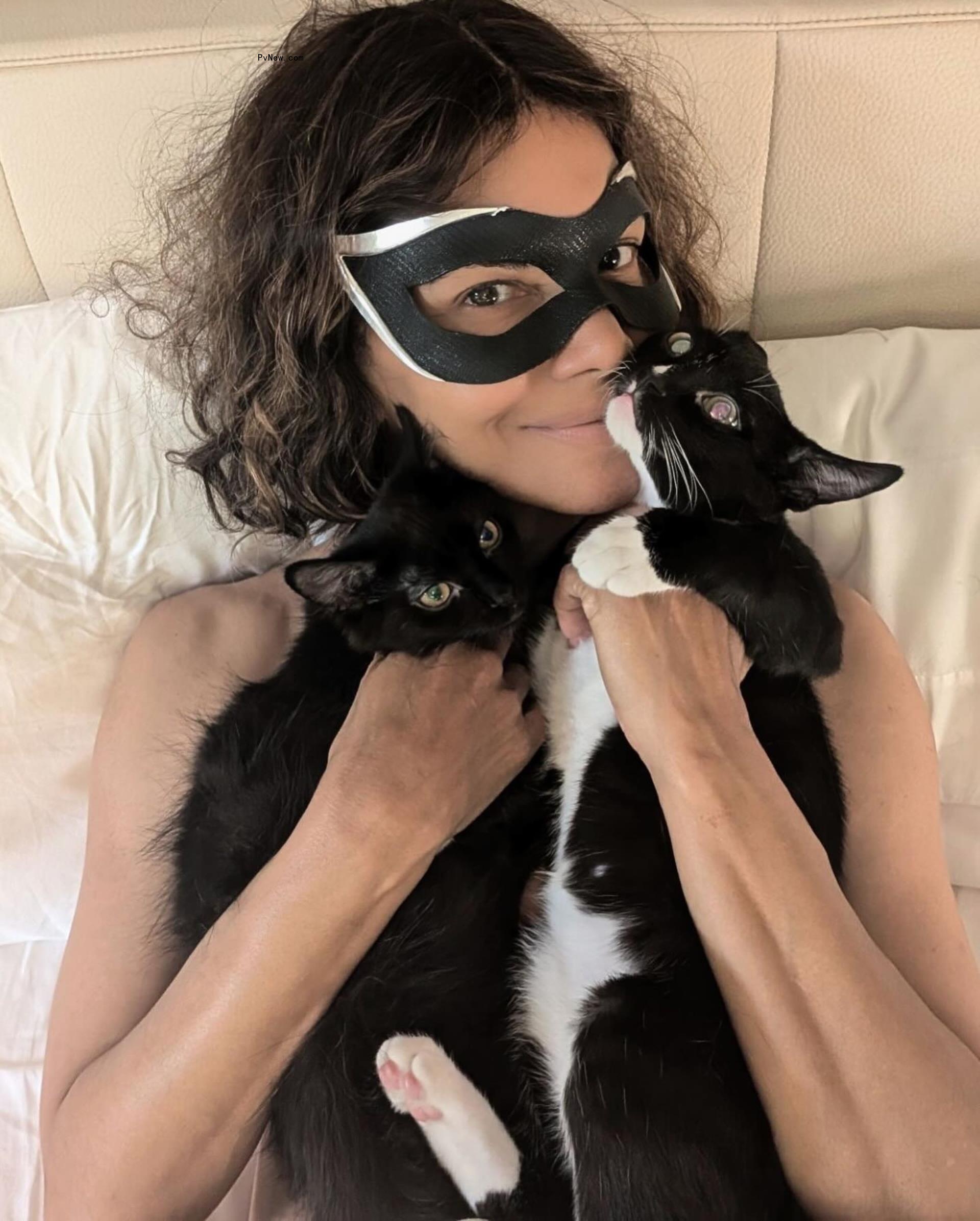 Halle Berry posing with two cats.