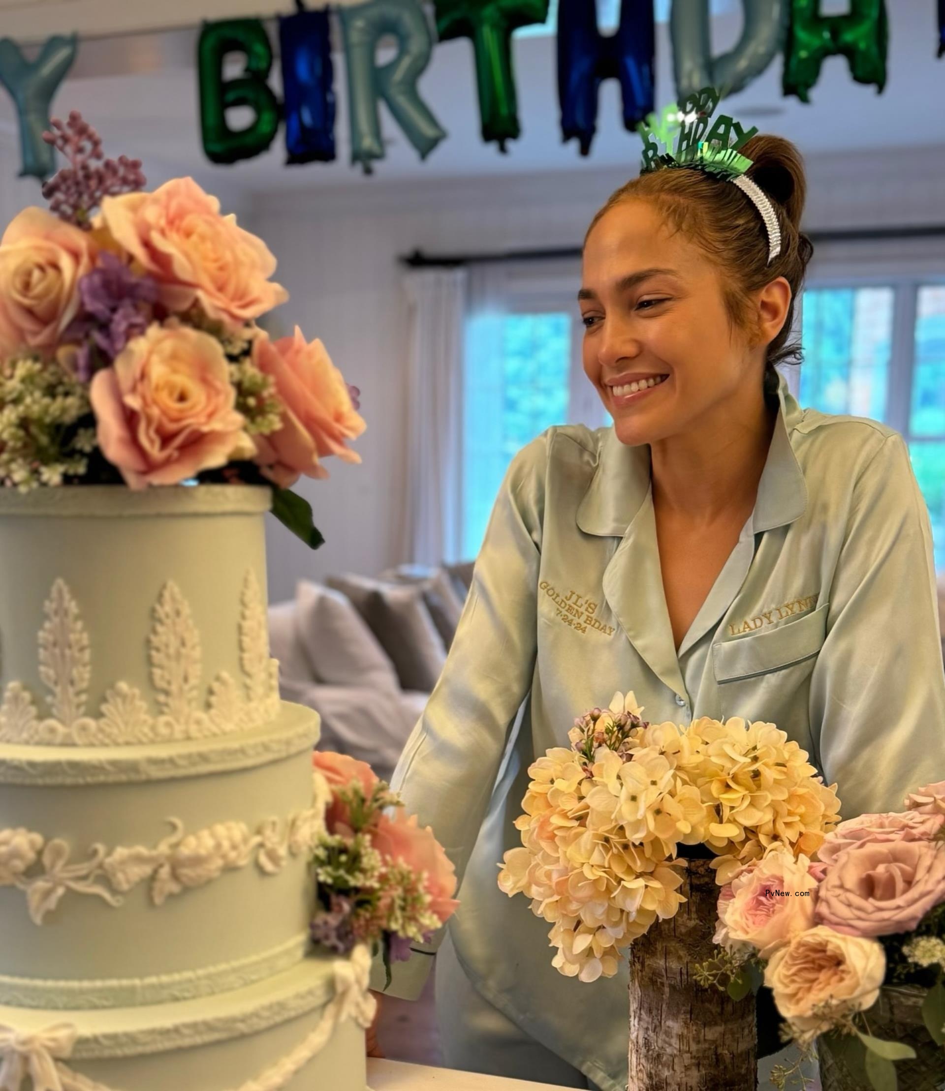Jennifer Lopez celebrating her birthday with a three-tier cake.