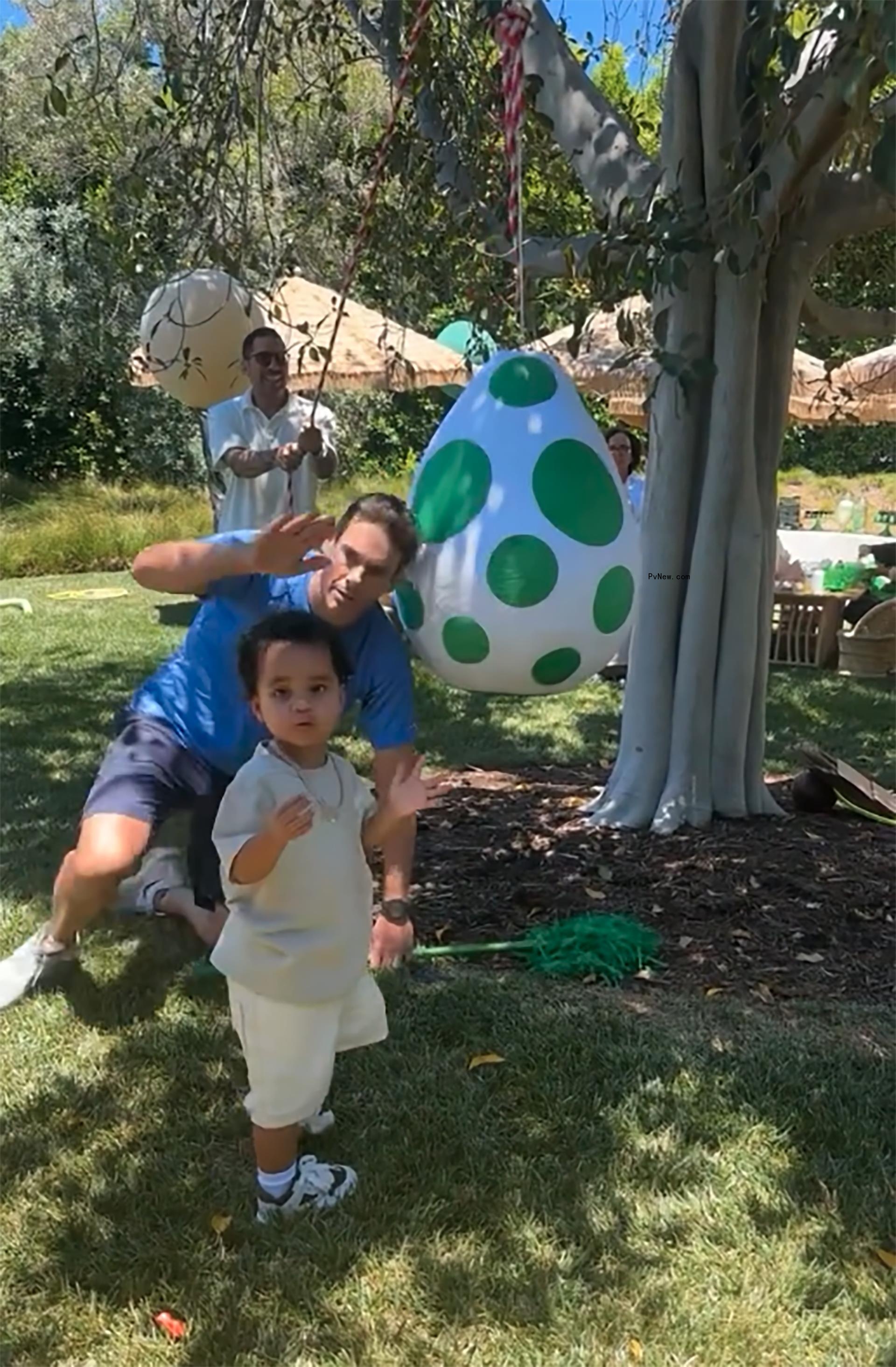 khloe kardashian's son tatum with an egg-shaped piñata and a man