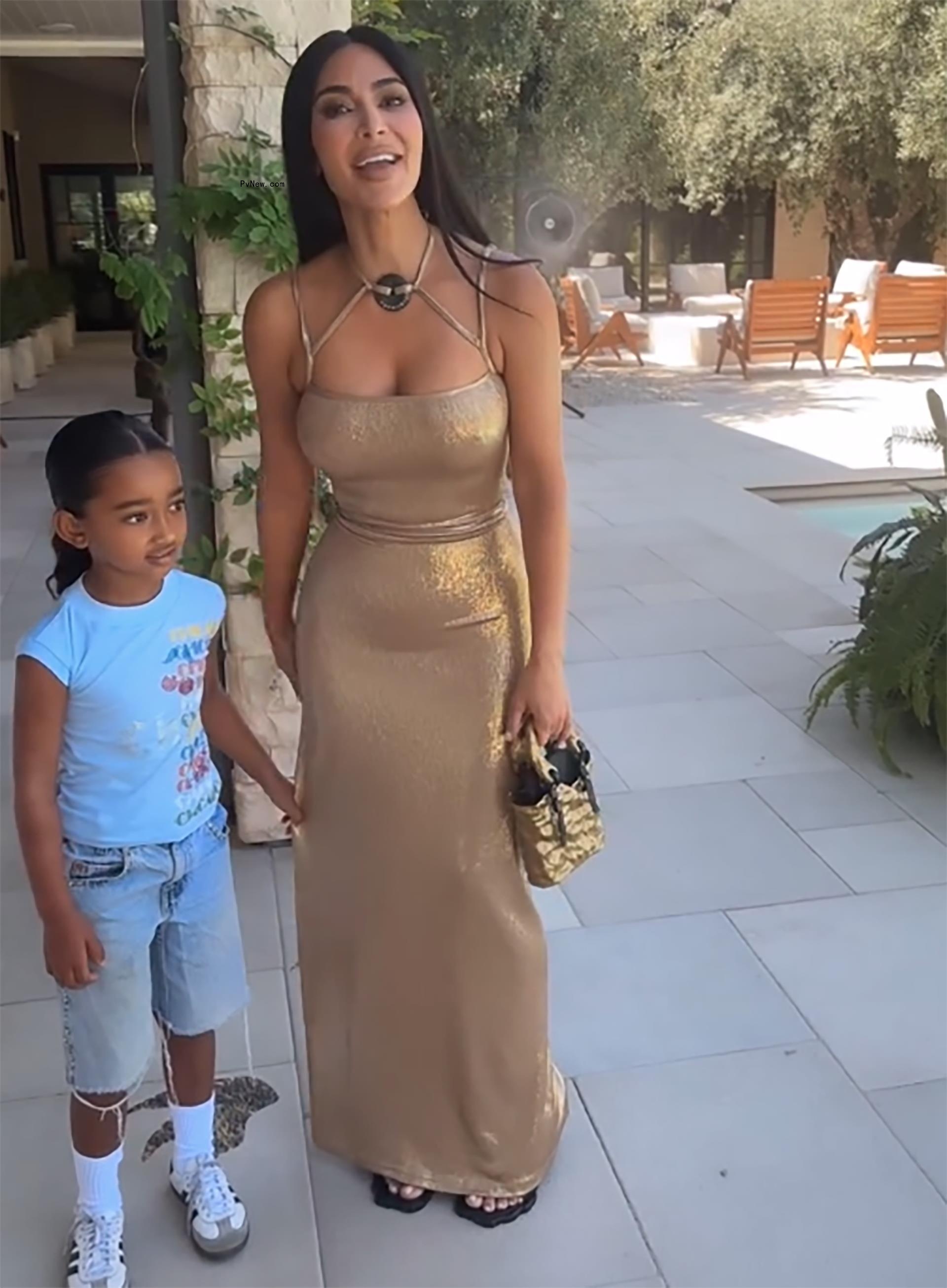 kim kardashian smiling as her daughter chicago clings to her