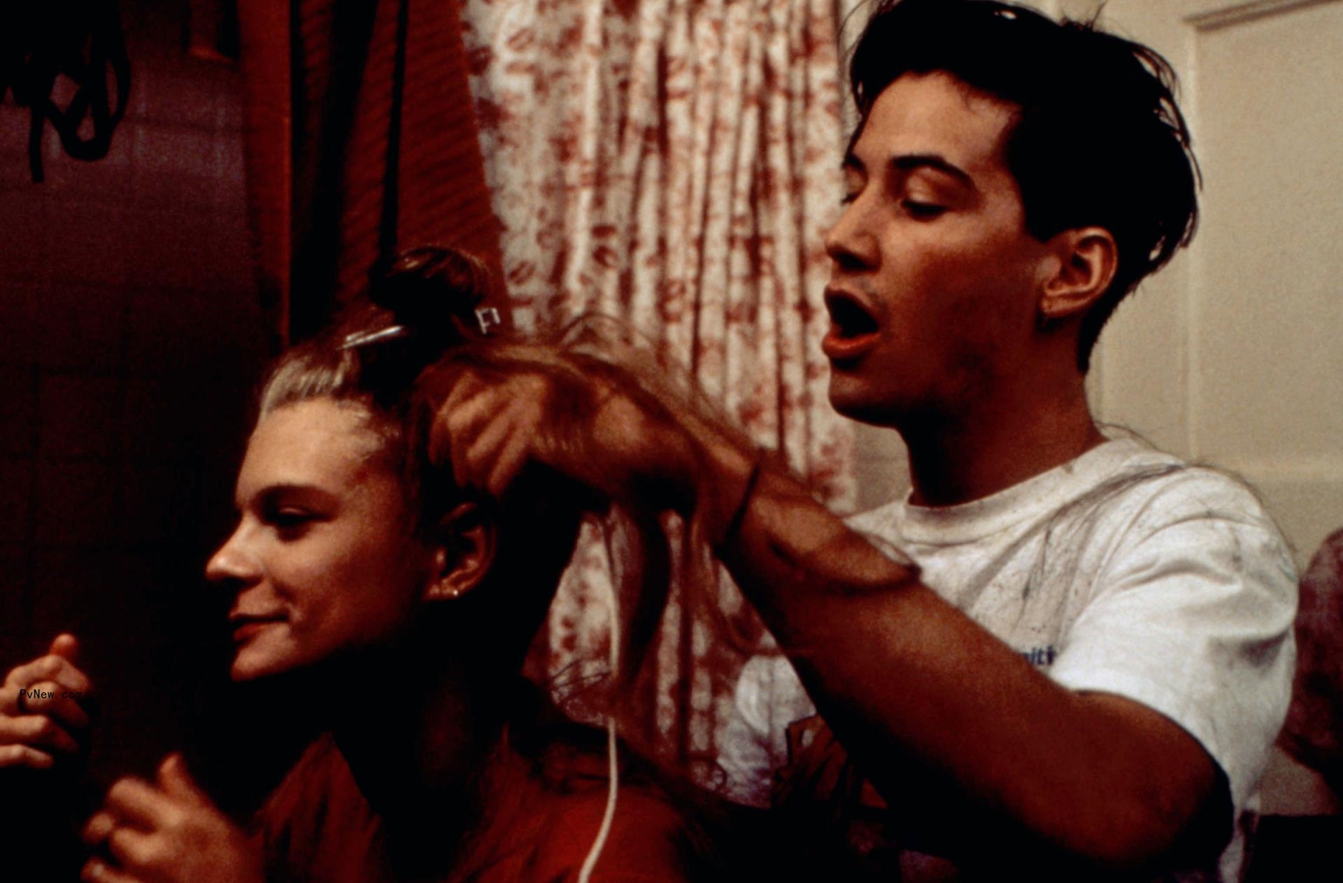 Keanu Reeves styles Martha Plimpton's hair in a