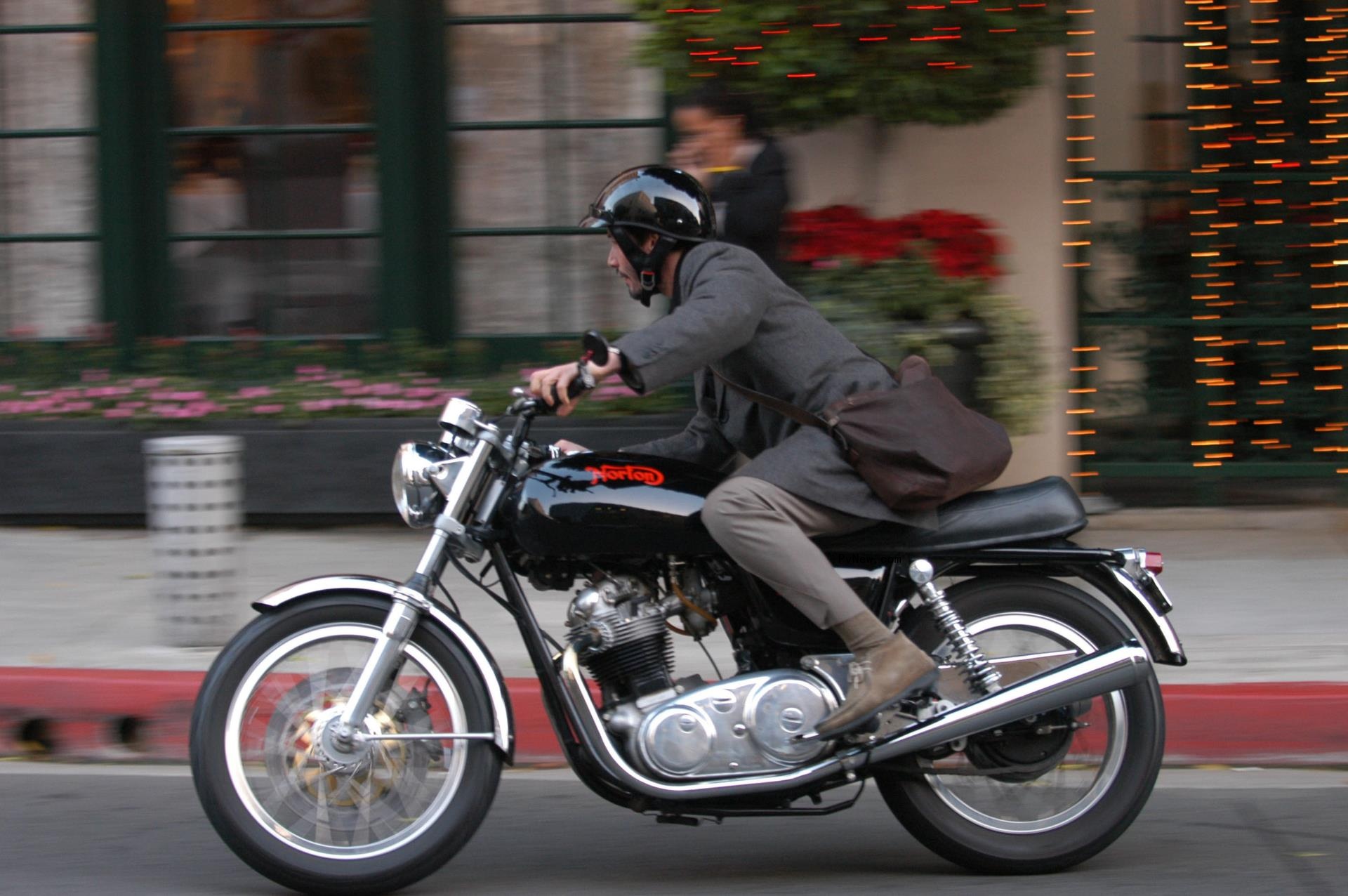 Keanu Reeves speeds along a street in Los Angeles on a motrorcycle.