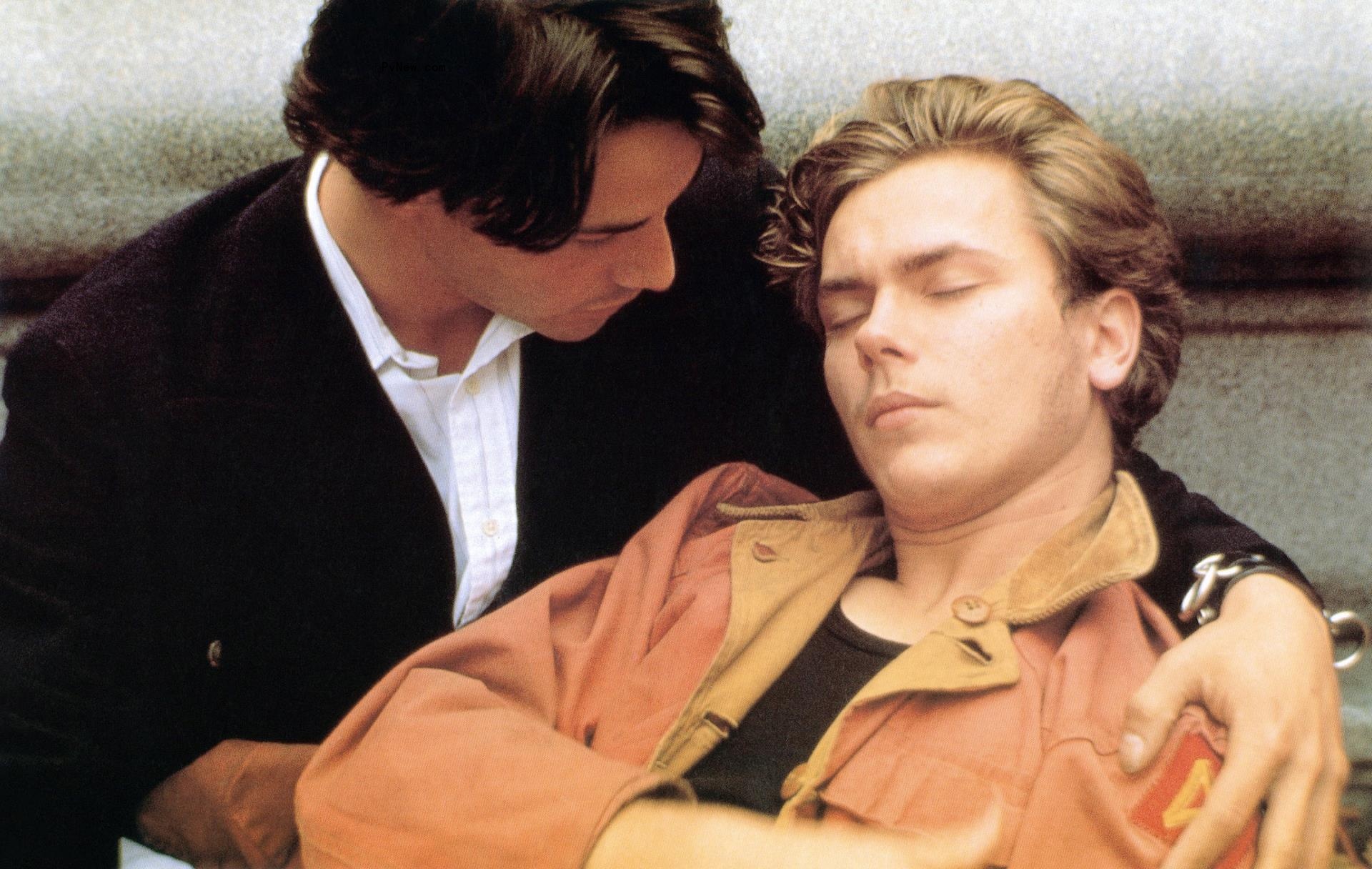 Keanu Reeves (left) cradles River Phoenix, who has his eyes closed, in a scene from