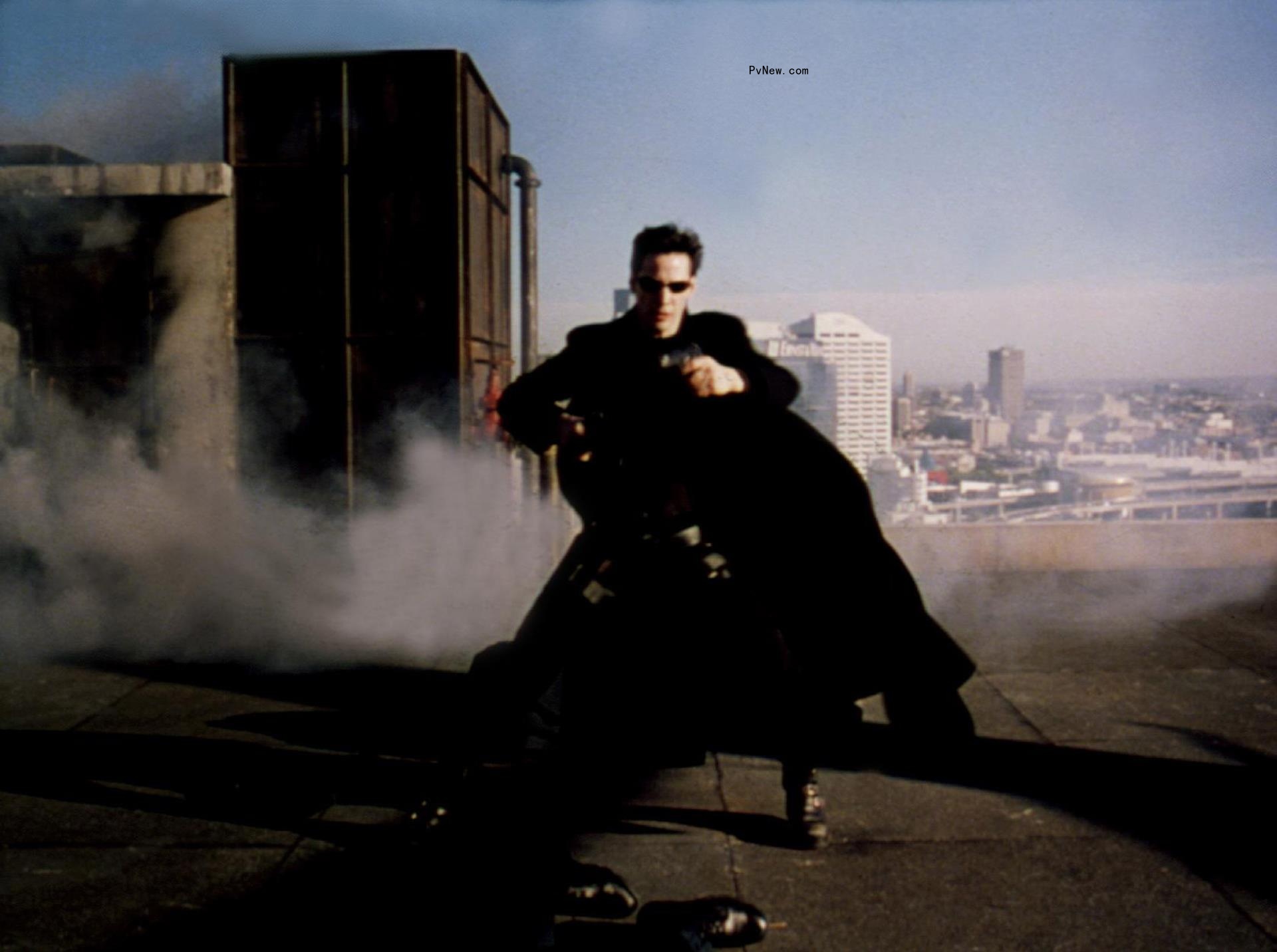 Keanu Reeves in black atop a building in a still from