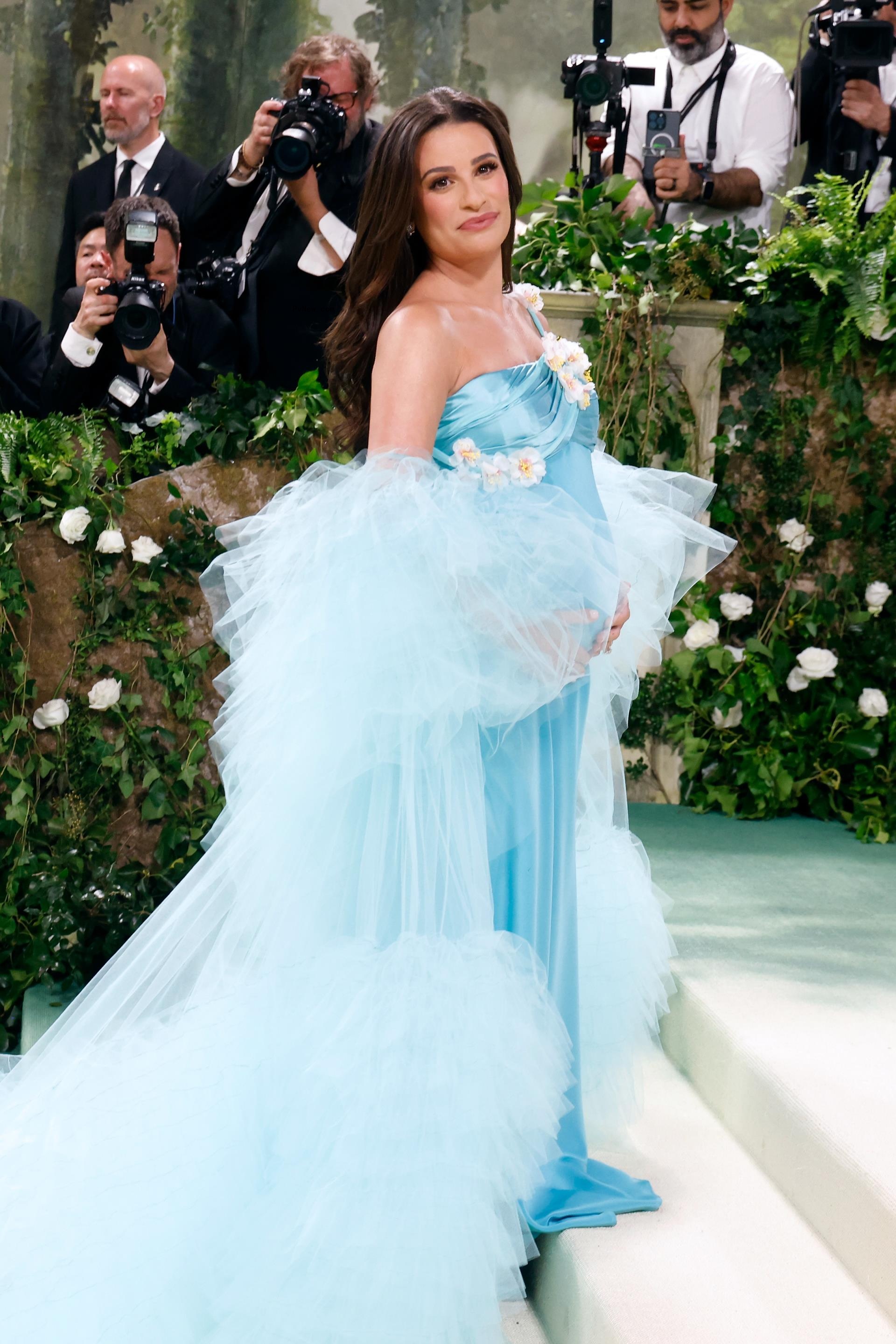 Michele cradles her bump in a blue dress at the May Met Gala.
