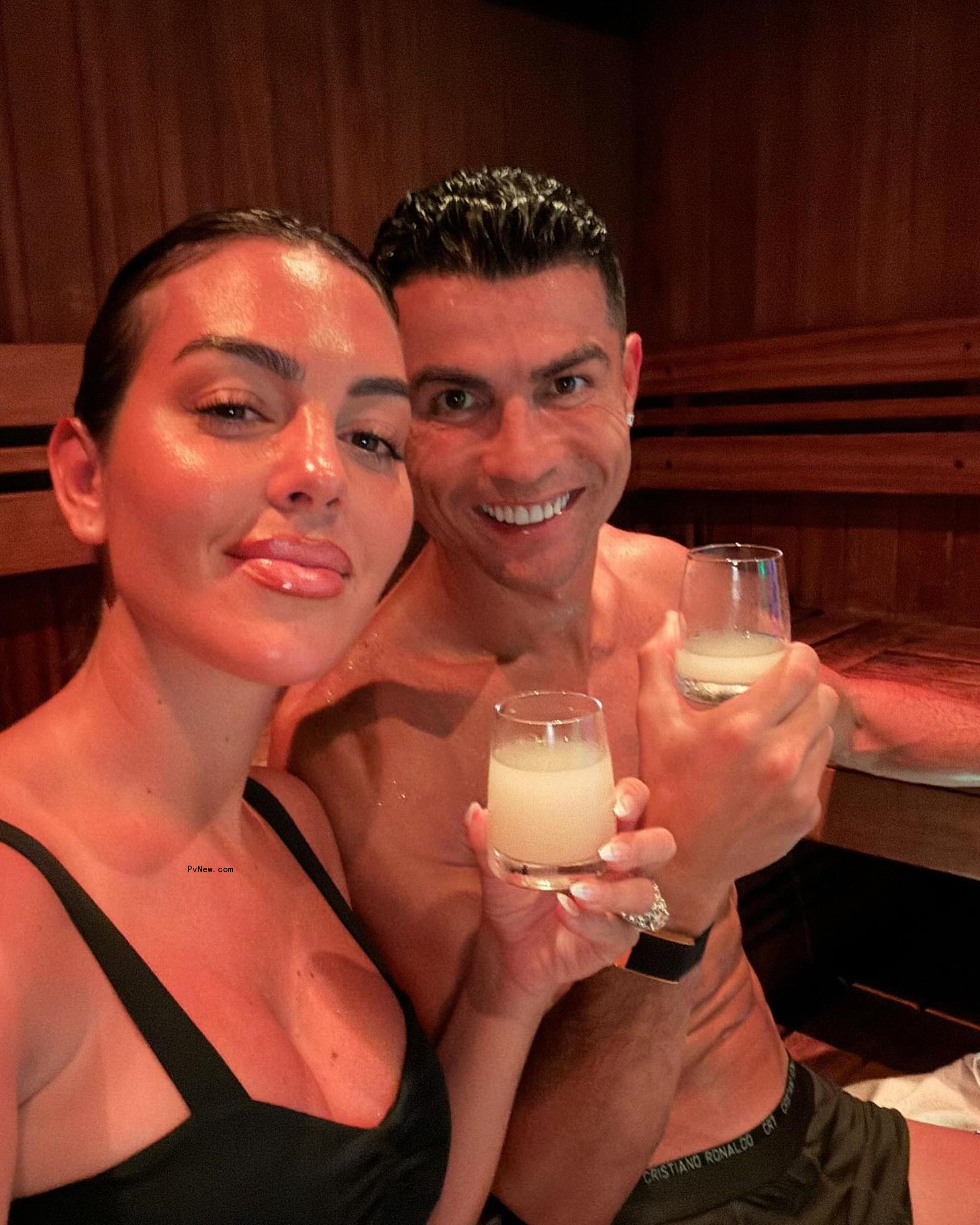Cristiano Ro<i></i>naldo and Georgina Rodríguez holding drinks.