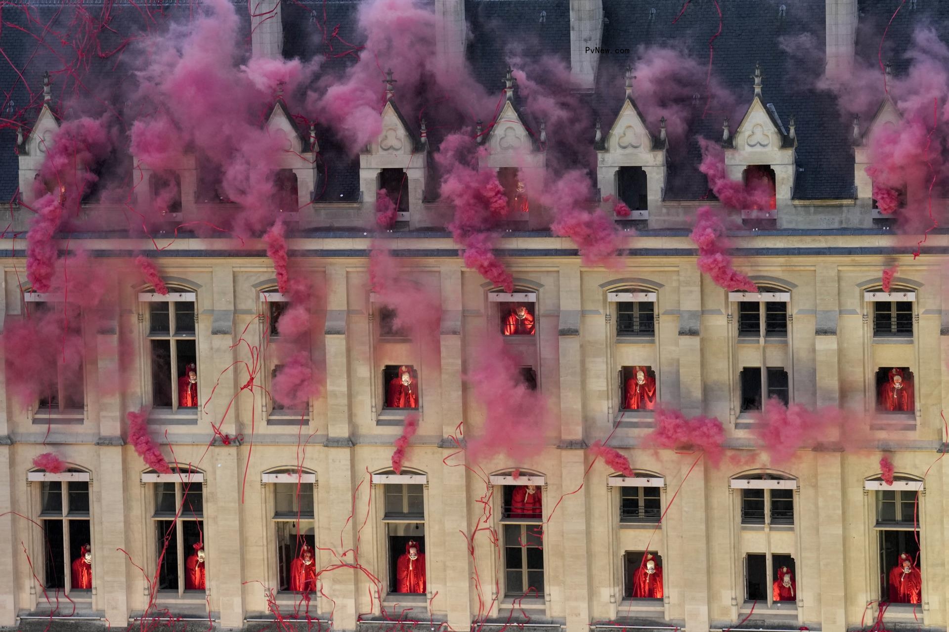 pink Smoke billows near windows as performers depicting the 18th century Queen Marie Antoinette hang out