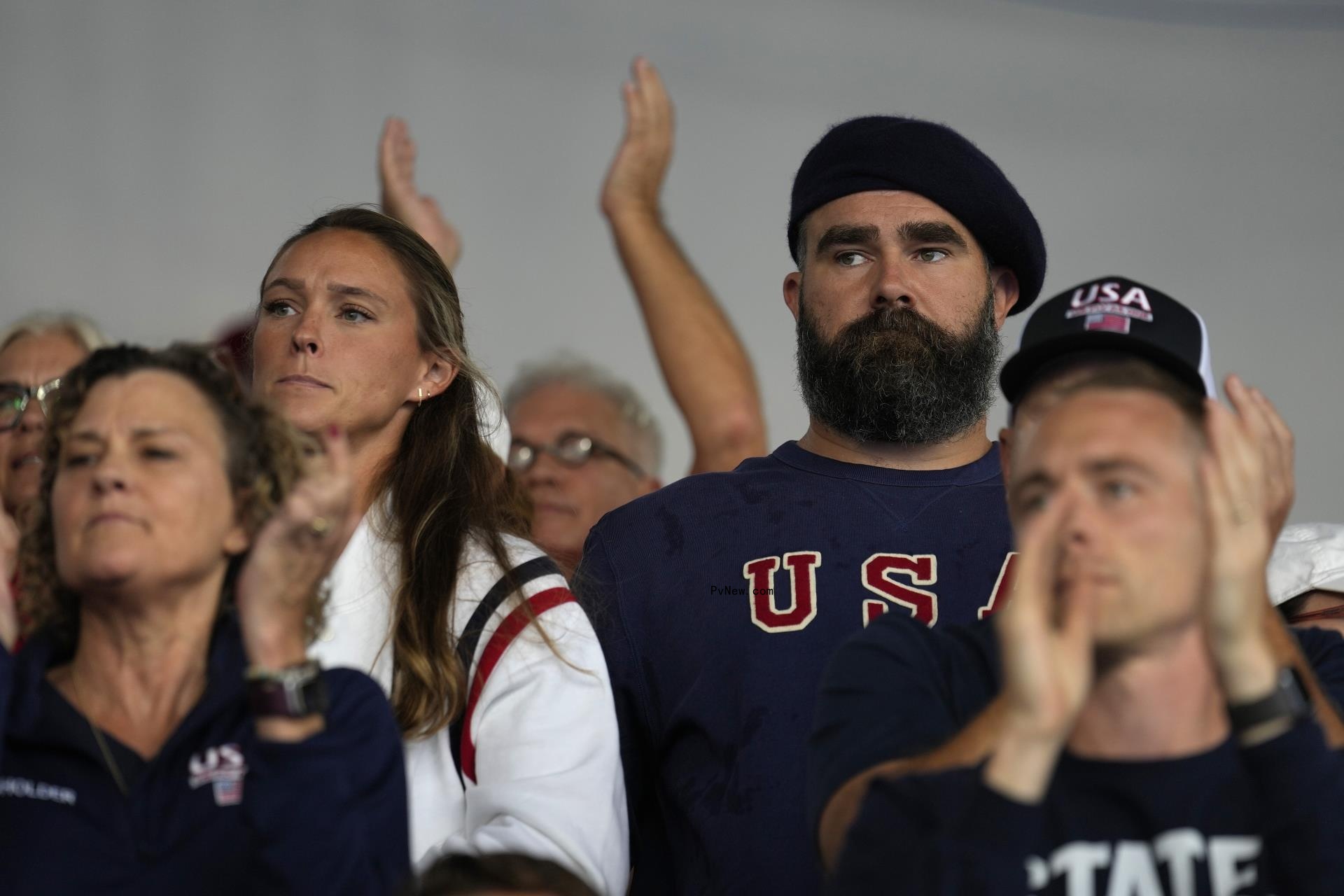 kylie and beret-clad jason kelce clapping in a crowd