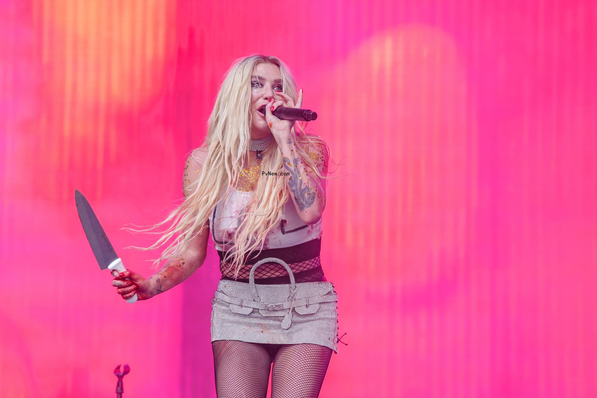 Kesha o<i></i>nstage with a knife.