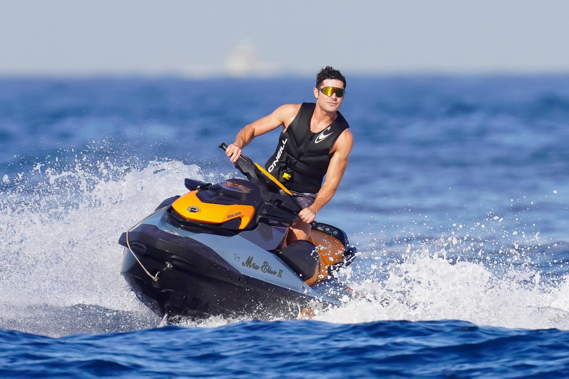 Zac Efron rides a jet ski on the water