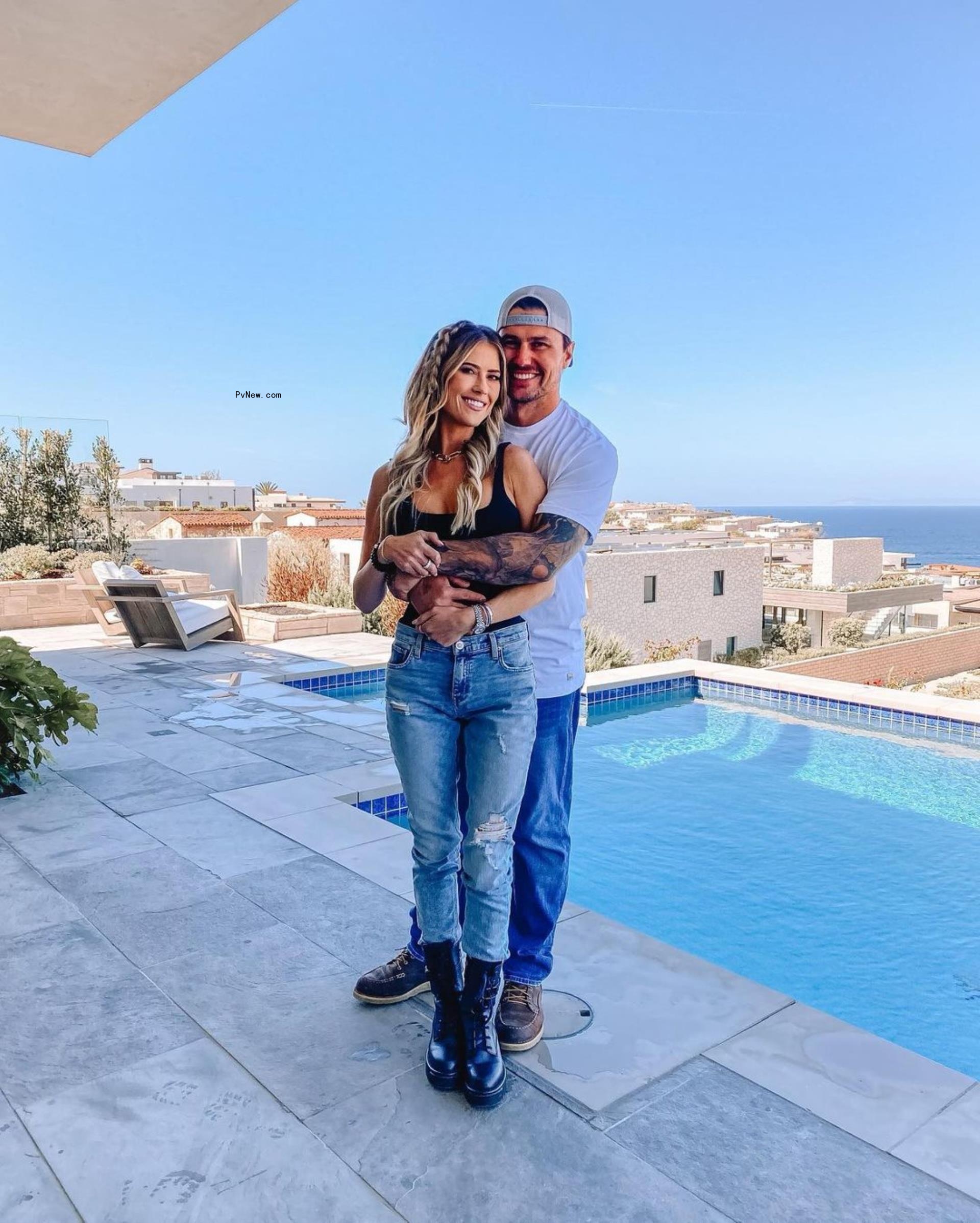 Christina and Josh Hall posing in front of a pool.