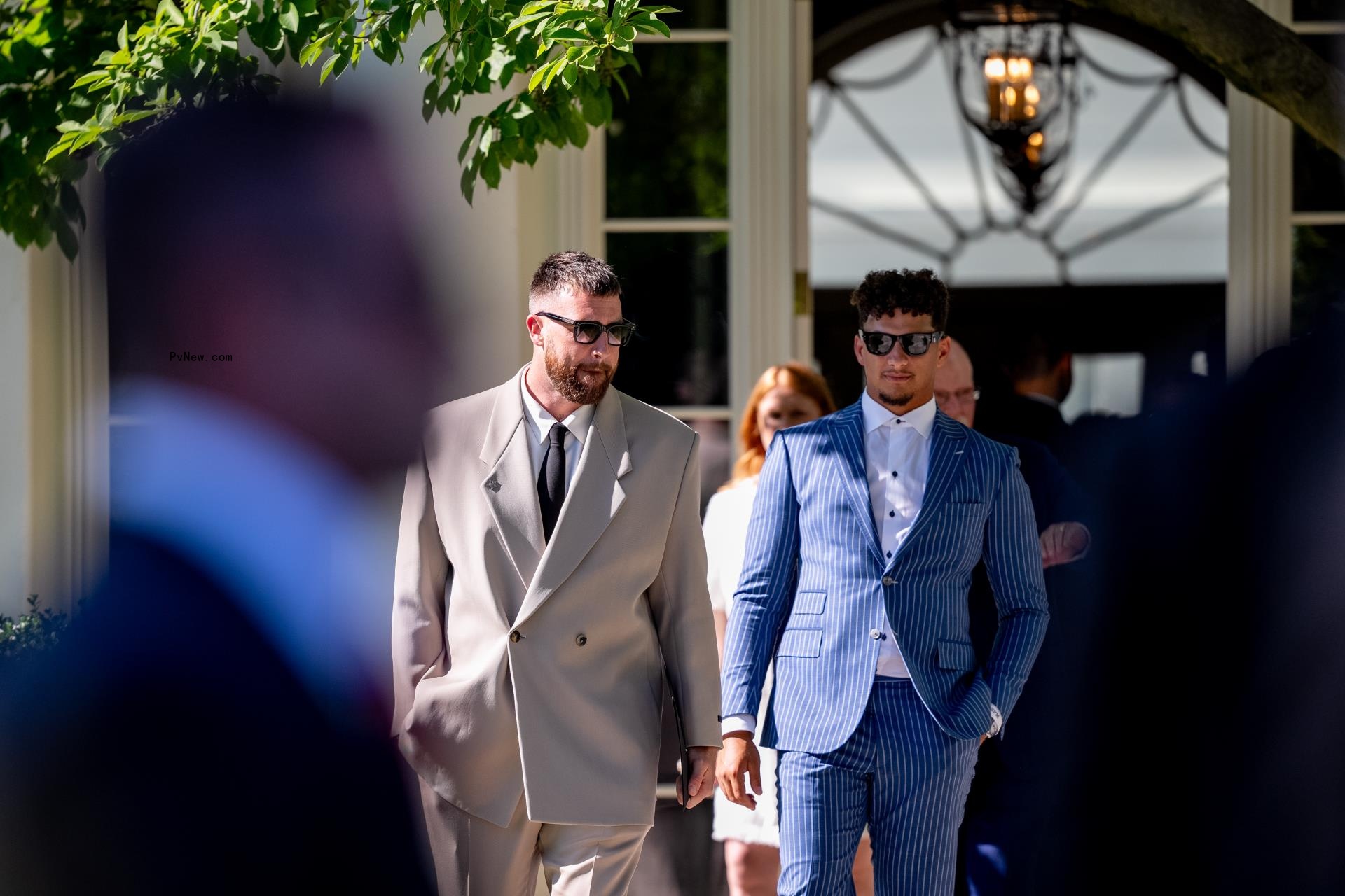 Travis Kelce (L) and Patrick Mahomes (R) walk out of the Palm Room into the Rose Garden following an event with U.S. President Joe Biden on the South Lawn of the White House on May 31, 2024.