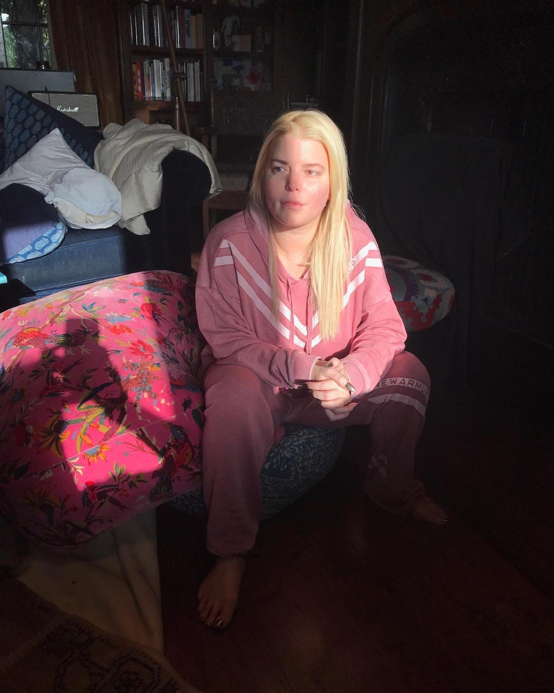 jessica simpson in a pink tracksuit sitting on a couch looking into the distance