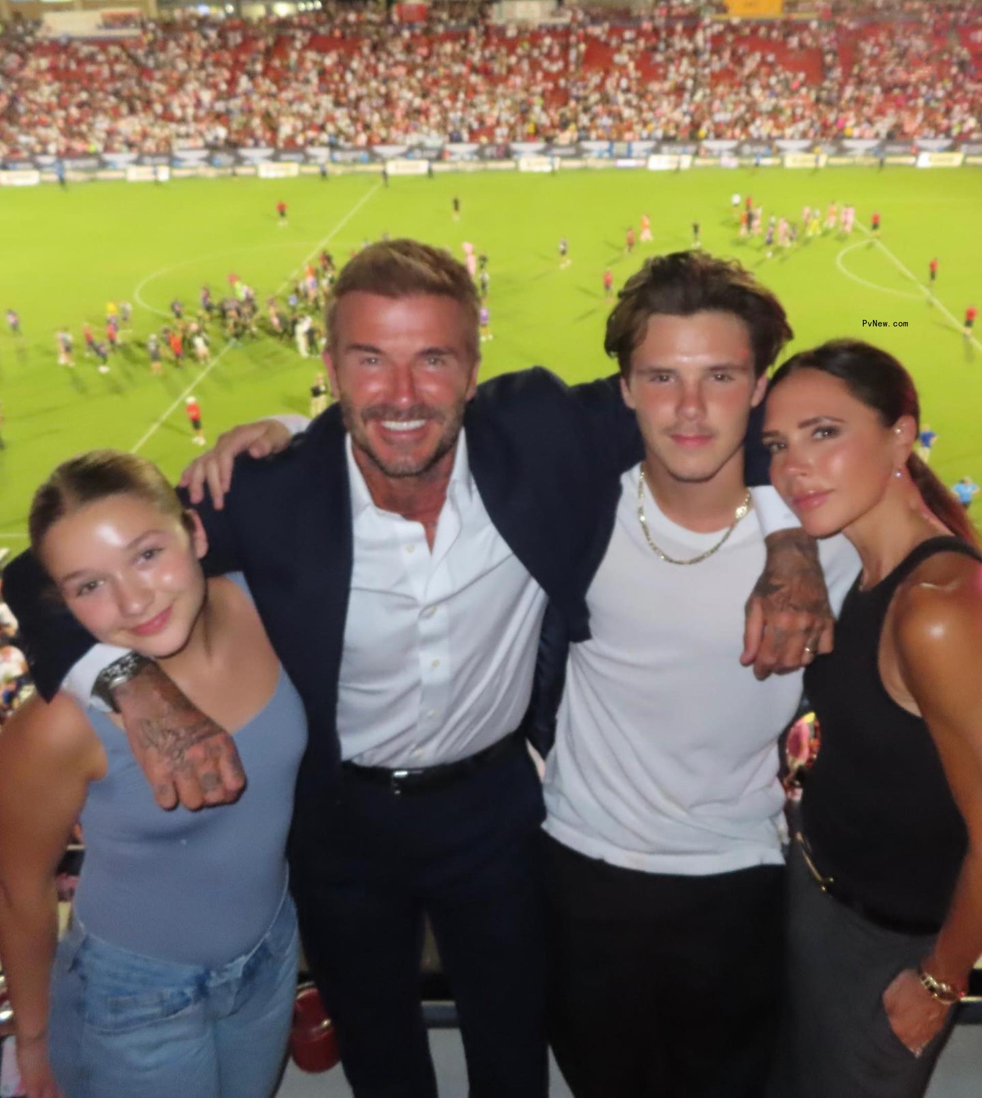 David and Victoria Beckham with their kids at a soccer game.