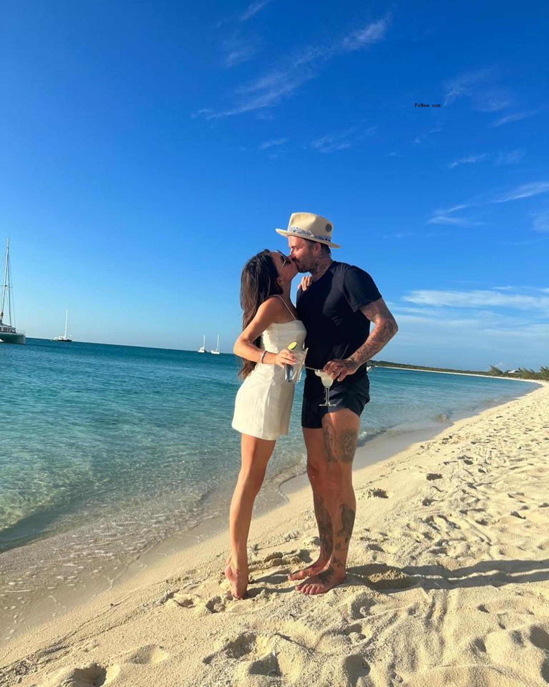 Victoria and David Beckham kissing on the beach.