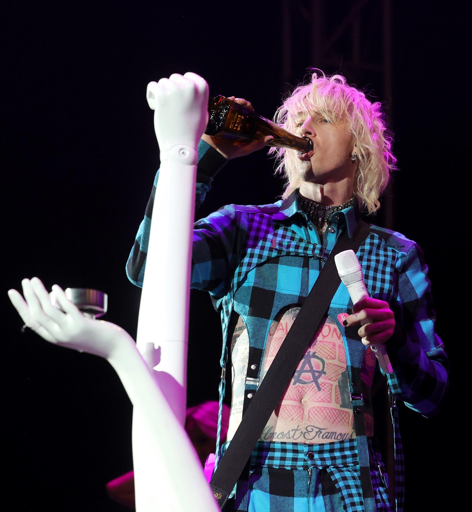 Machine Gun Kelly drinks at February 2023 Sports Illustrated Super Bowl party