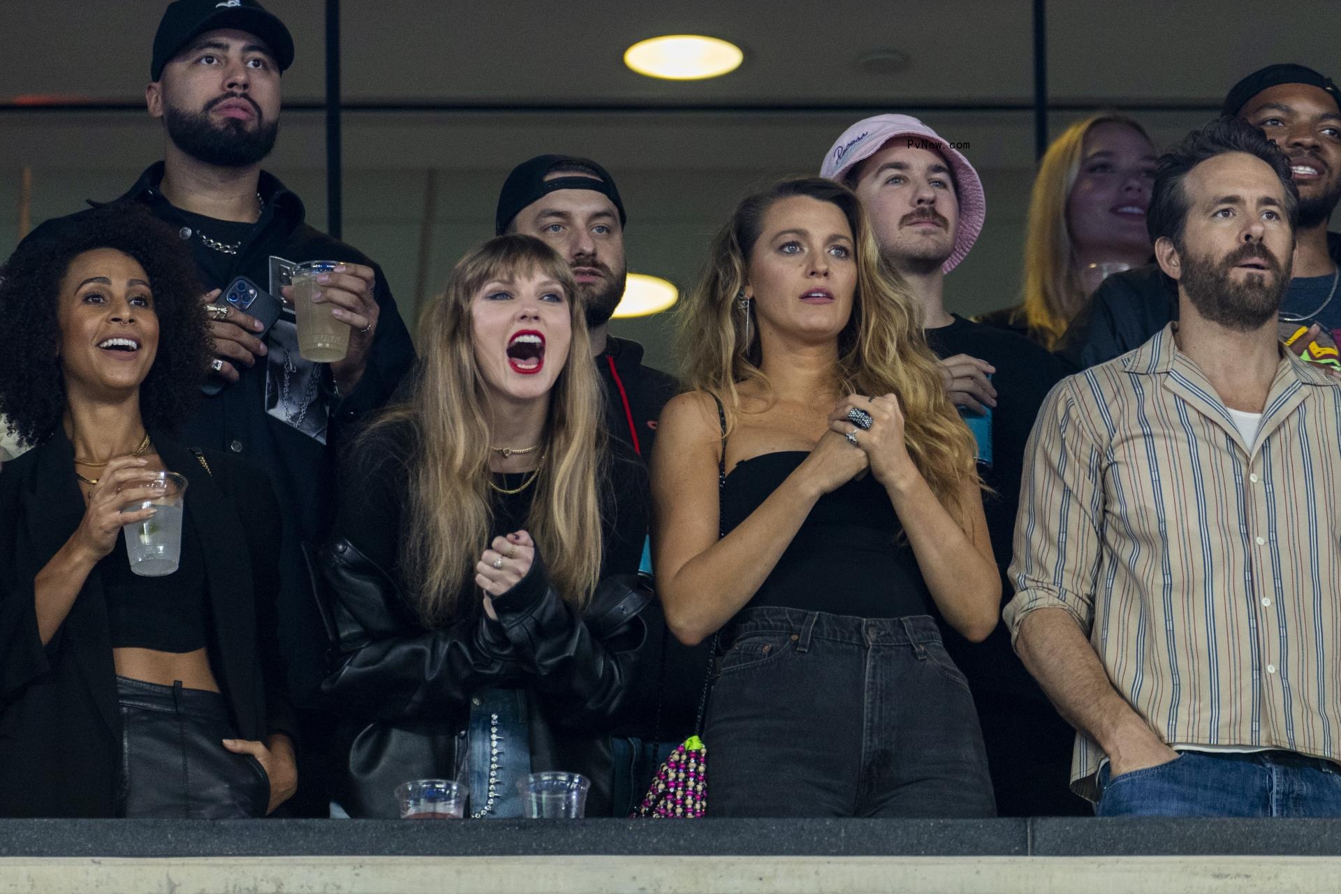 Artist Taylor Swift reacts along side actor Blake Lively and Ryan Reynolds in the first half at MetLife Stadium, Sunday, Oct. 1, 2023.
