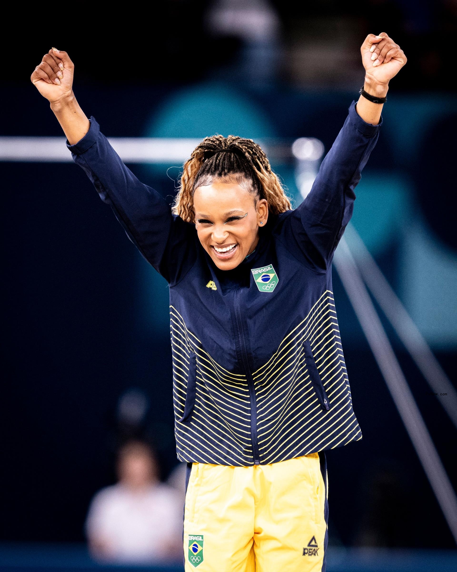 brazilian gymnast rebeca andrade with her arms in the air in celebration