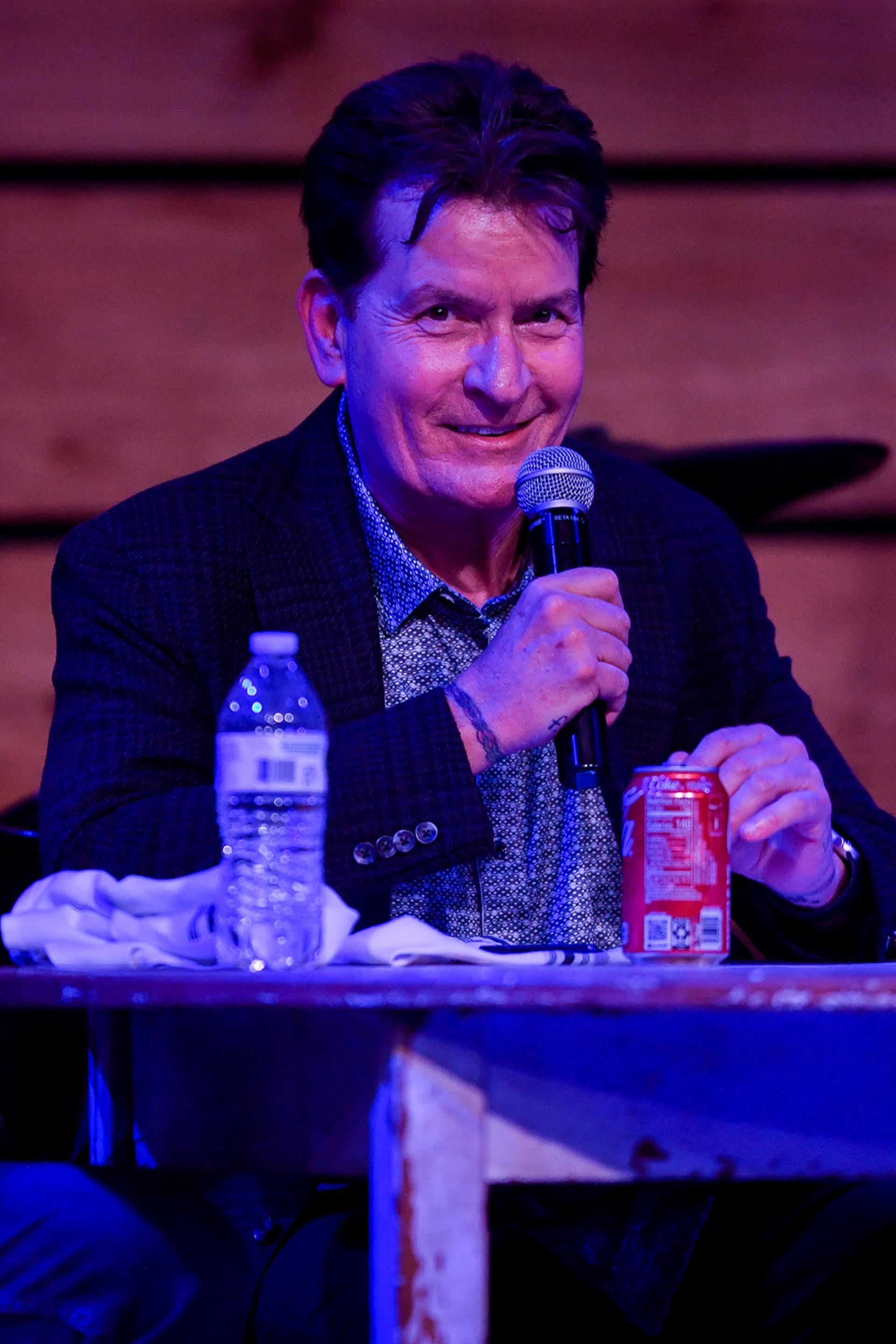 Charlie Sheen holding a mic.