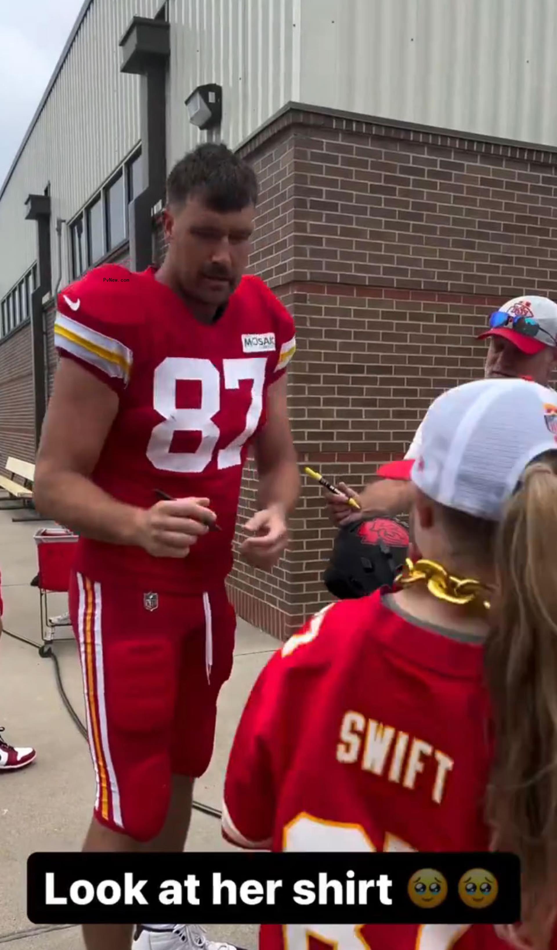 Travis Kelce signing a jersey