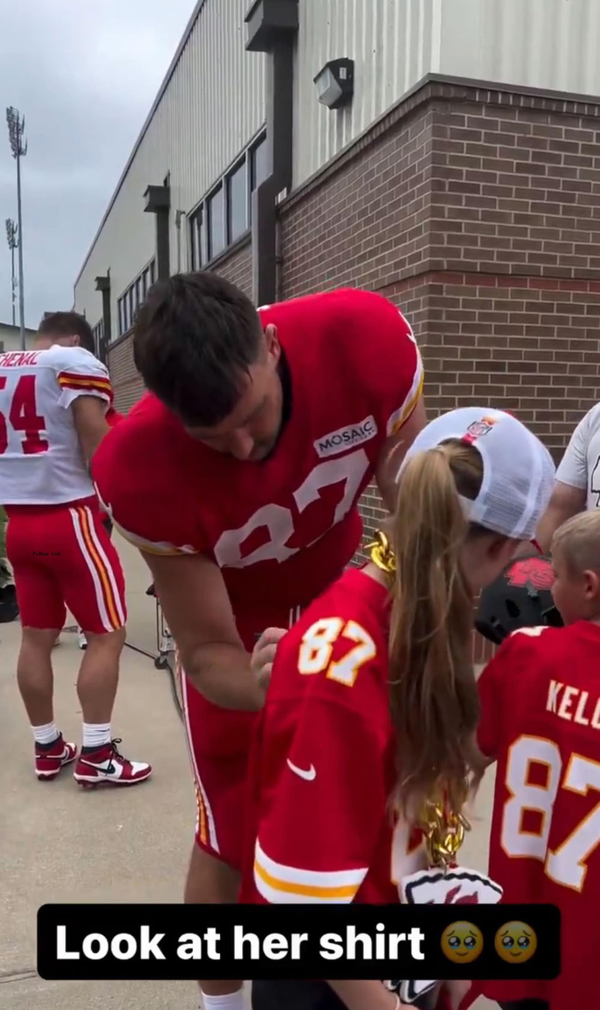 Travis Kelce signing a jersey
