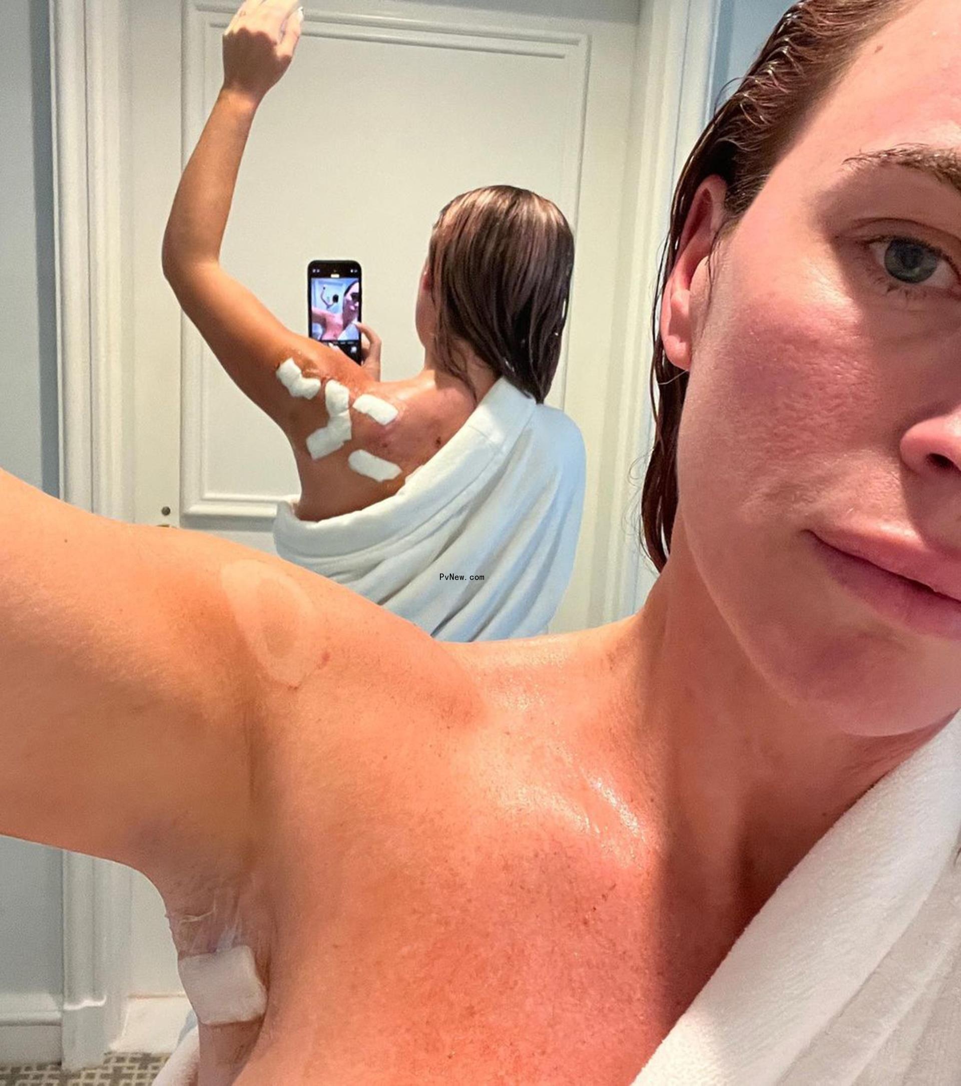 towel-clad teddi mellencamp taking a mirror selfie to show bandages on her back