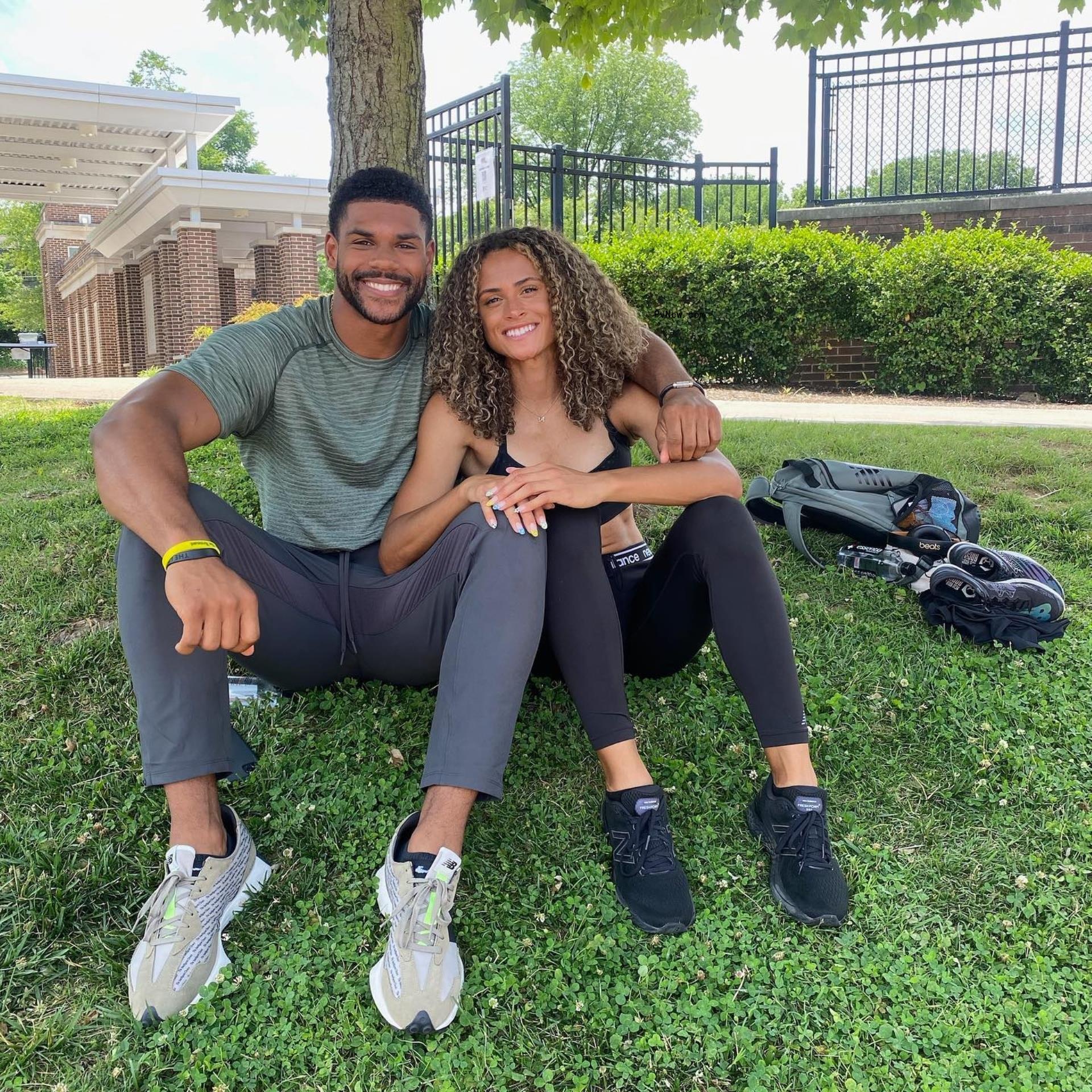 Sydney McLaughlin and Andre Levrone under a tree.