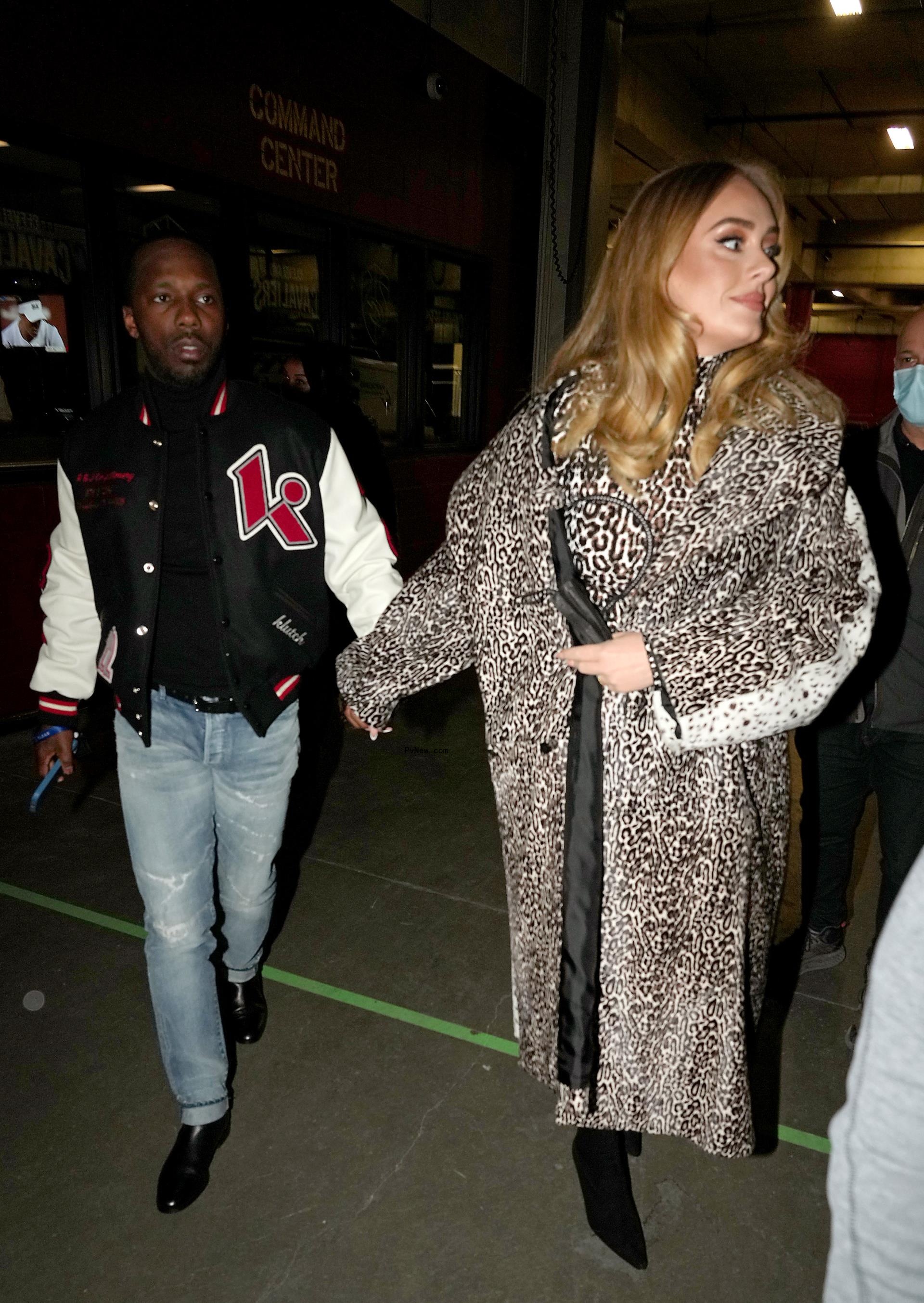 Adele and Rich Paul holding hands.