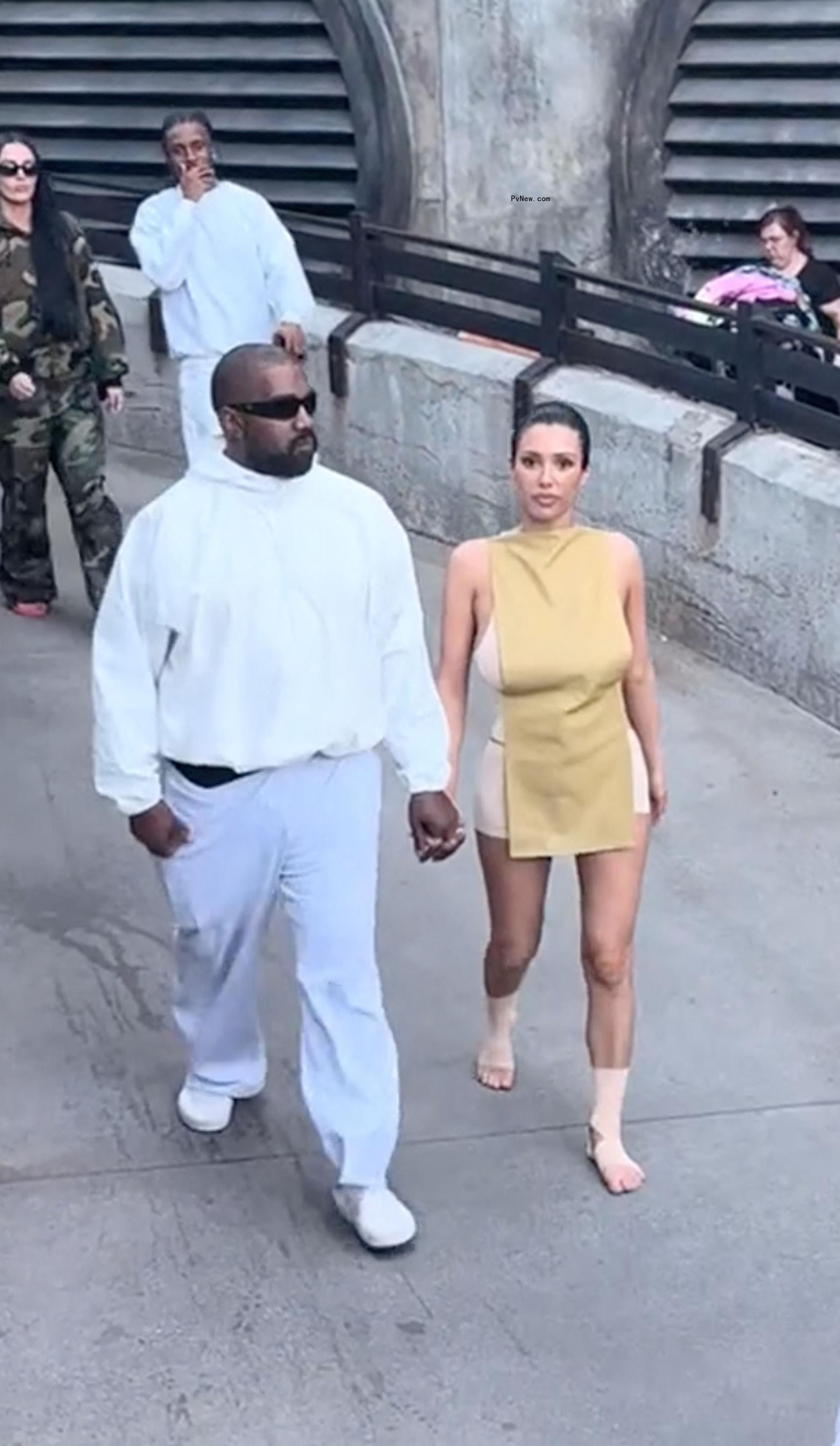 Bianca Censori and Kanye West holding hands.