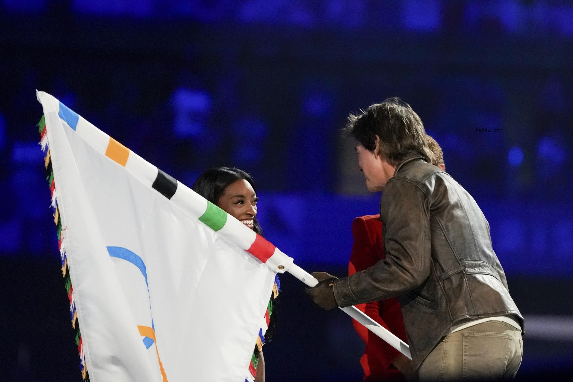 Tom Cruise takes the Olympic flag from US gymnast Simone Biles during the 2024 Summer Olympics closing ceremony at the Stade de France